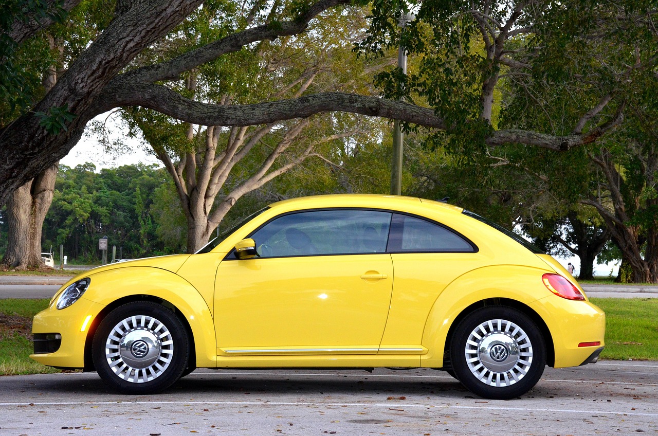 Carro compacto em posto de combustível com bico abastecendo