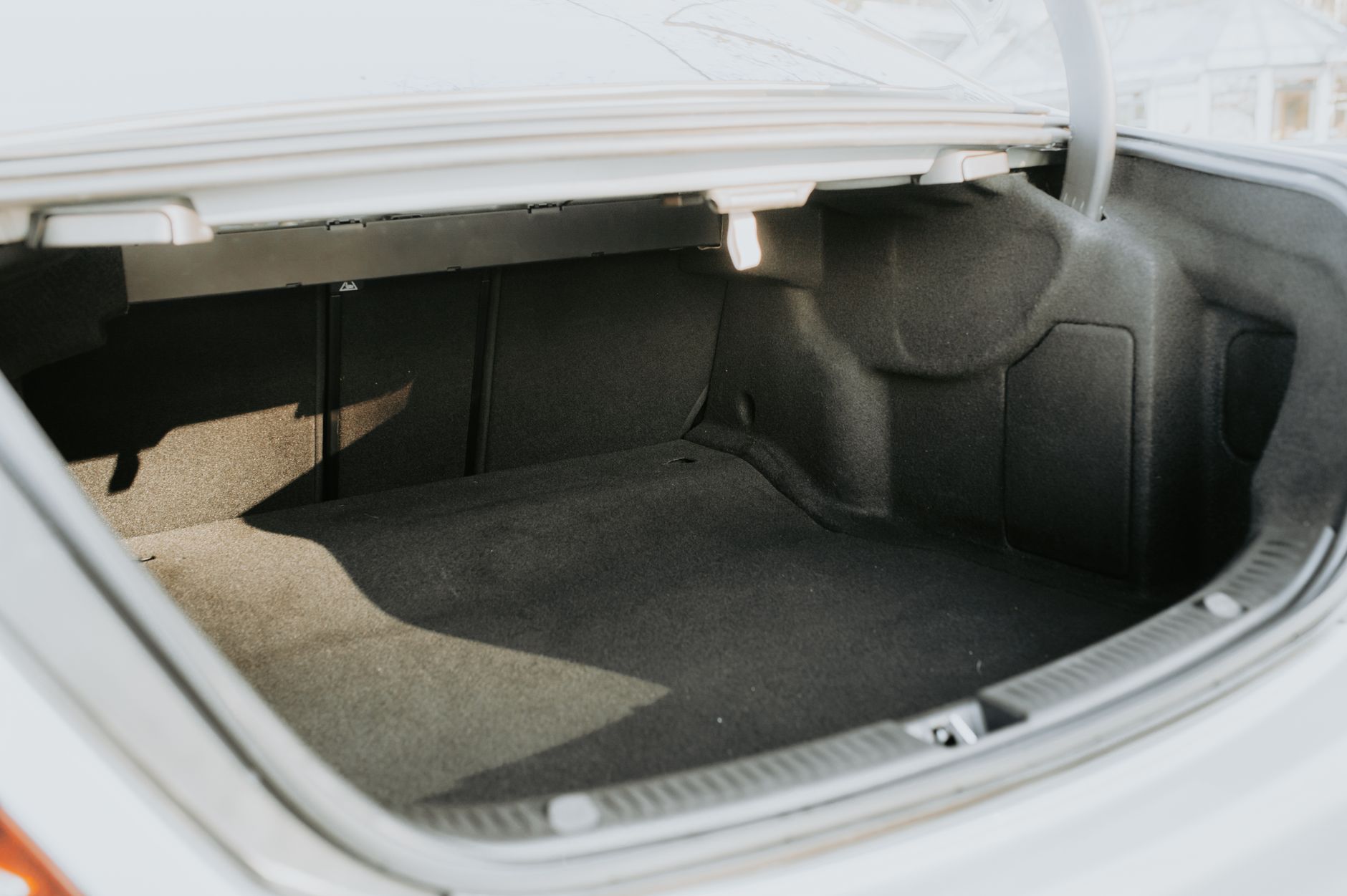 Família colocando bagagens no porta-malas de um carro seminovo