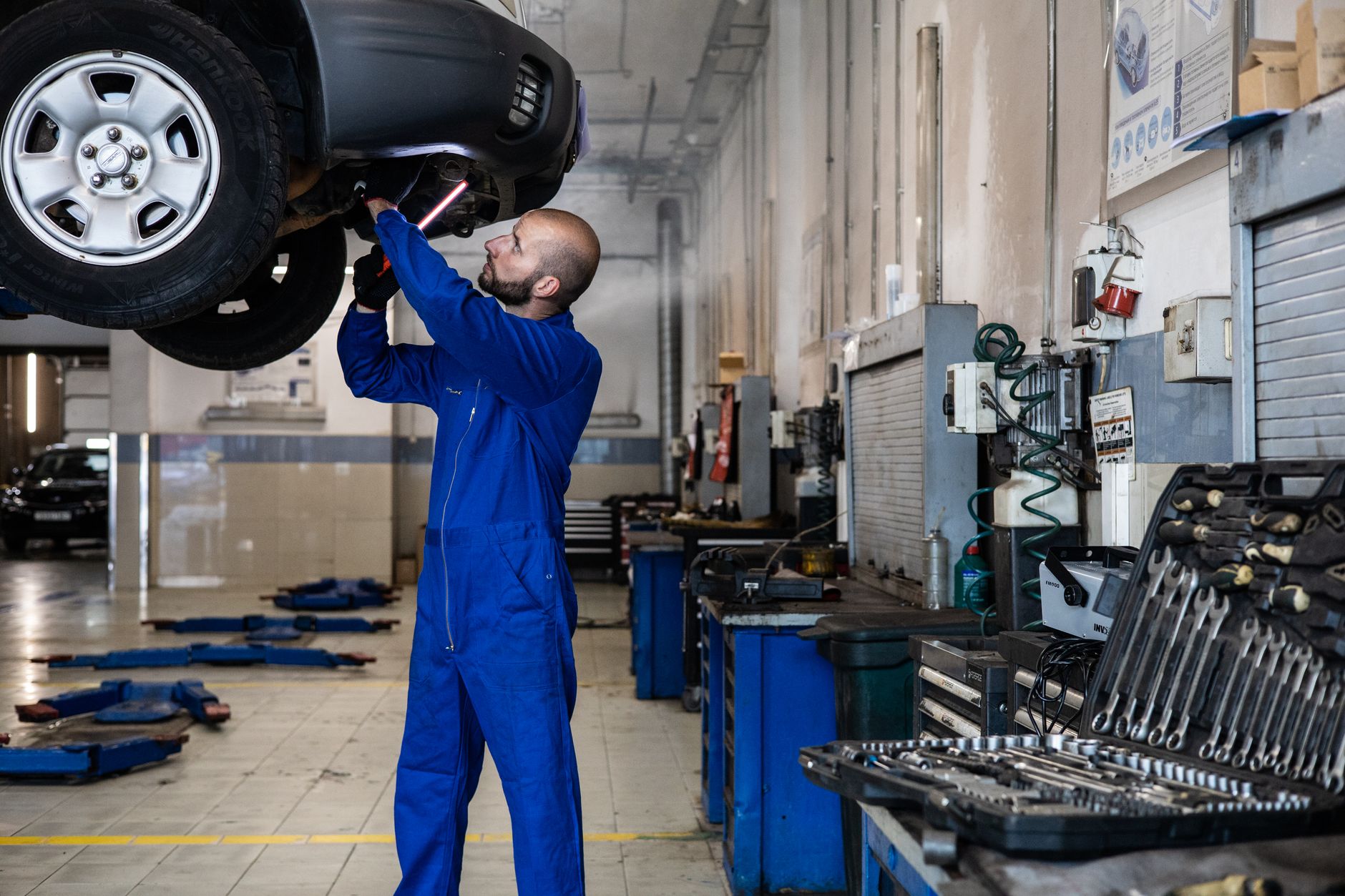 Mecânico inspecionando motor de carro em oficina