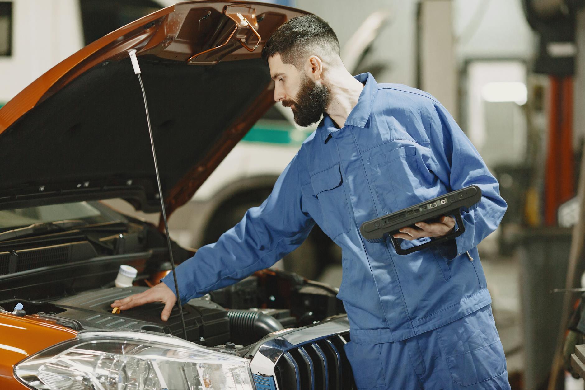 Mecânico inspecionando transmissão automática de sedan seminovo