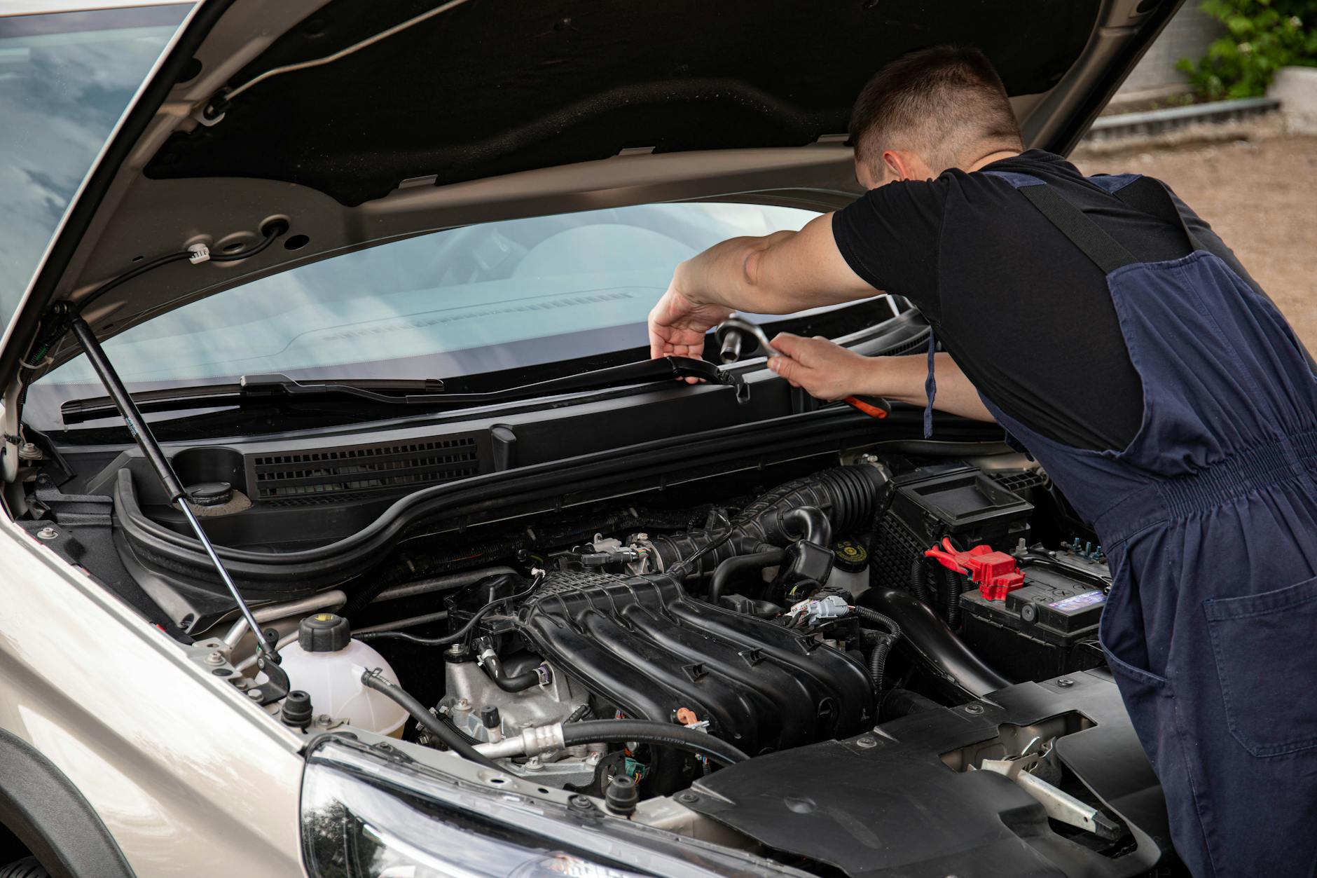 Mecânico inspecionando motor de carro usado