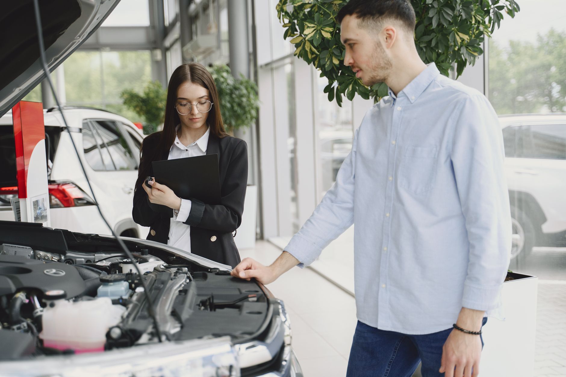 Mecânico verificando o motor de um carro seminovo