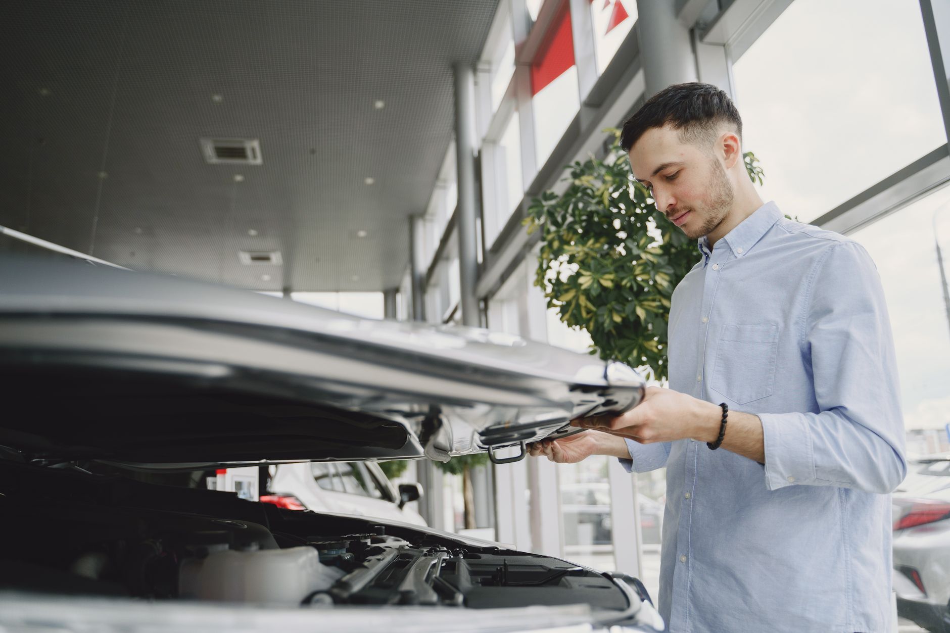 Mecânico inspecionando motor de carro seminovo