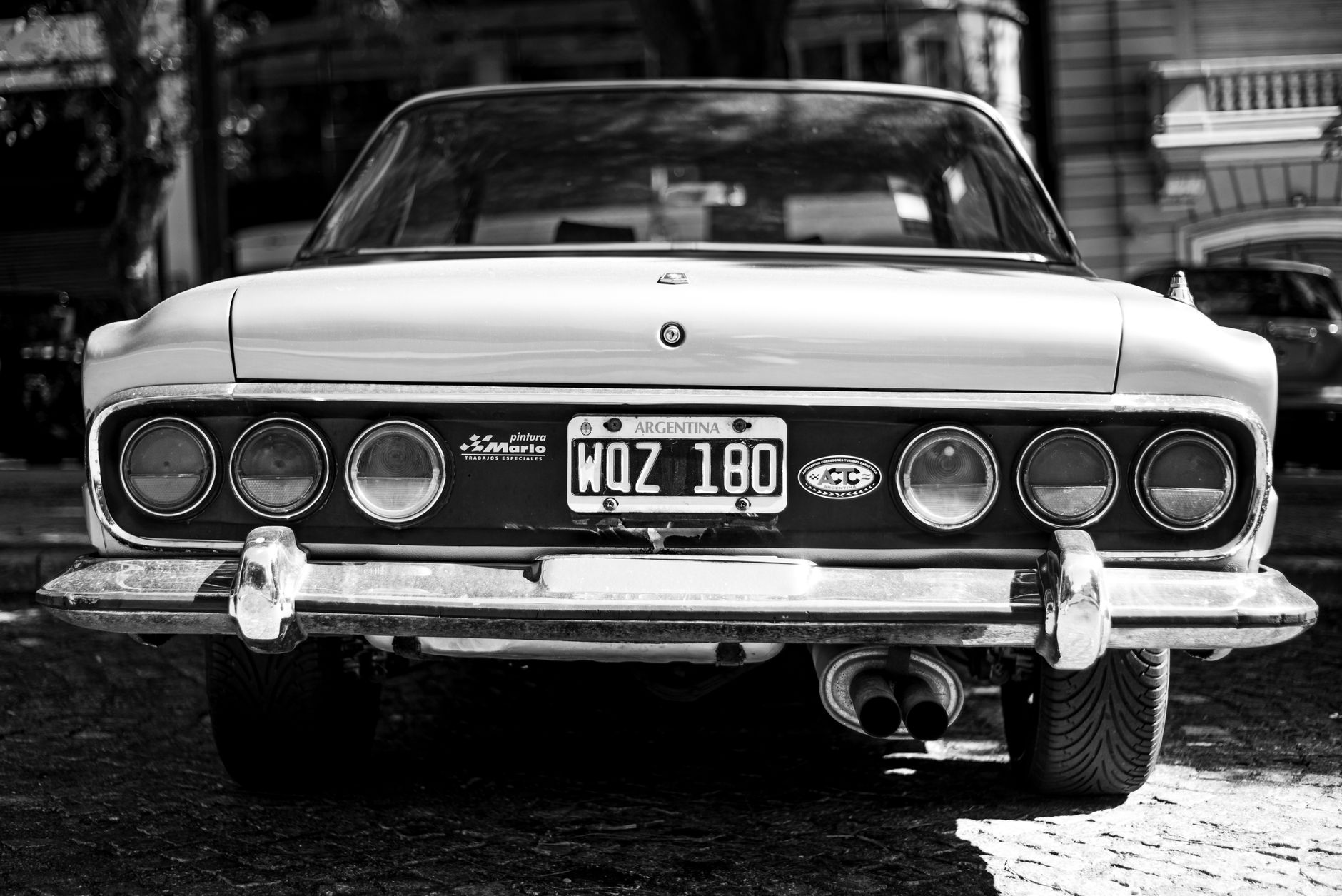 Monochrome rear view of a vintage car in Buenos Aires, showcasing urban street photography.
