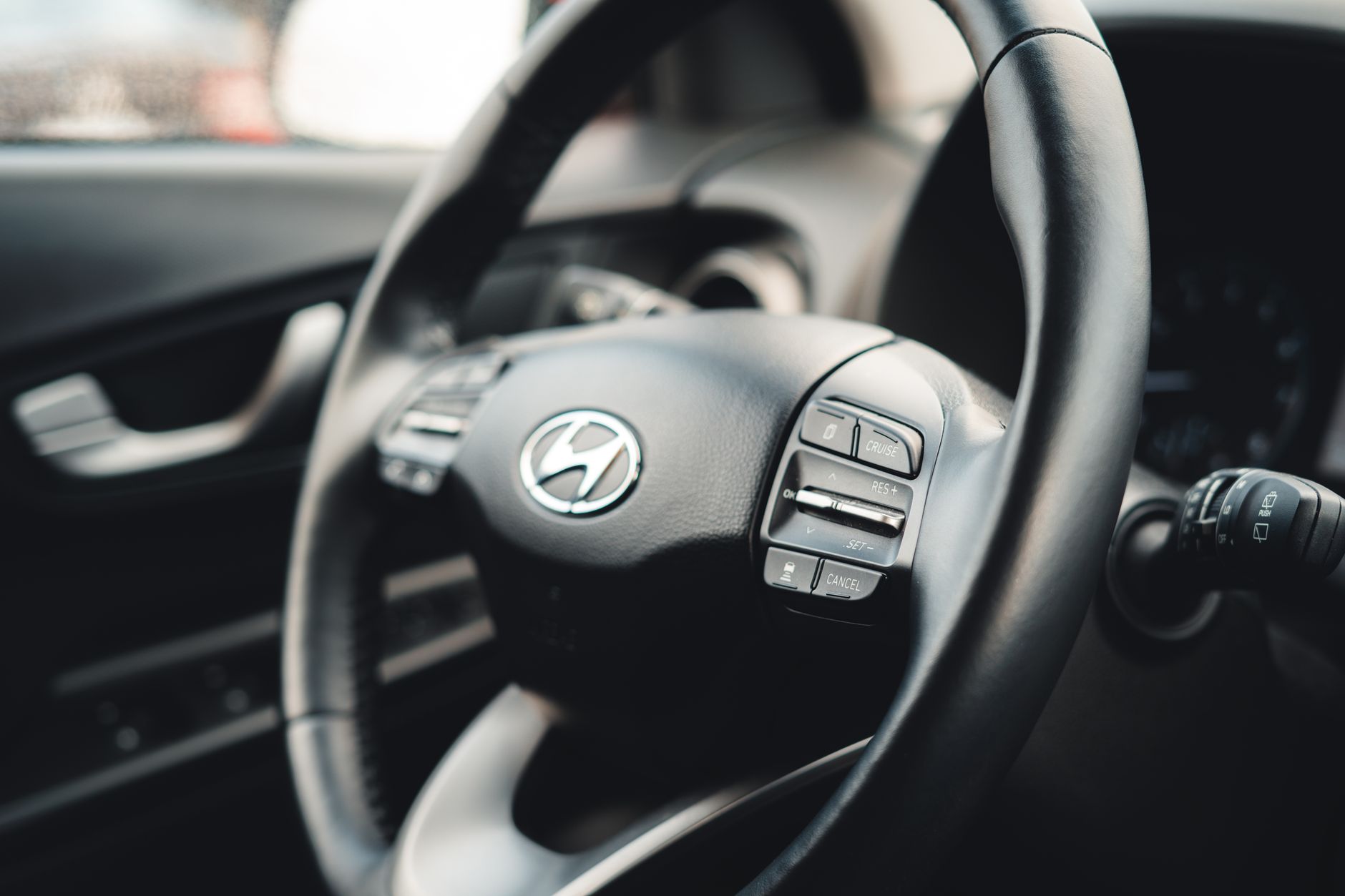 Close-up view of the car steering wheel showcasing interior design details.