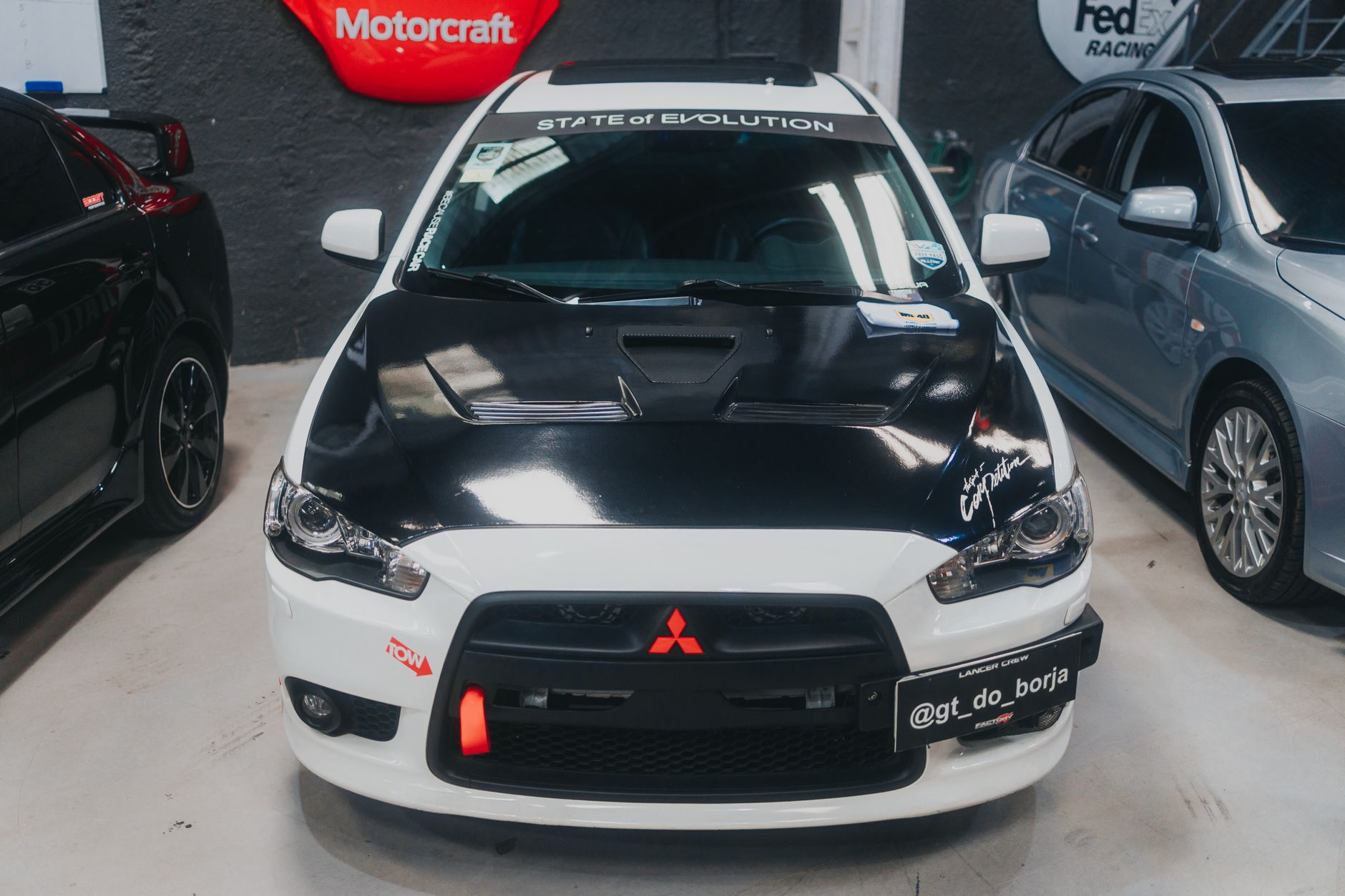 High-performance Mitsubishi Lancer with unique modifications parked in an indoor garage.