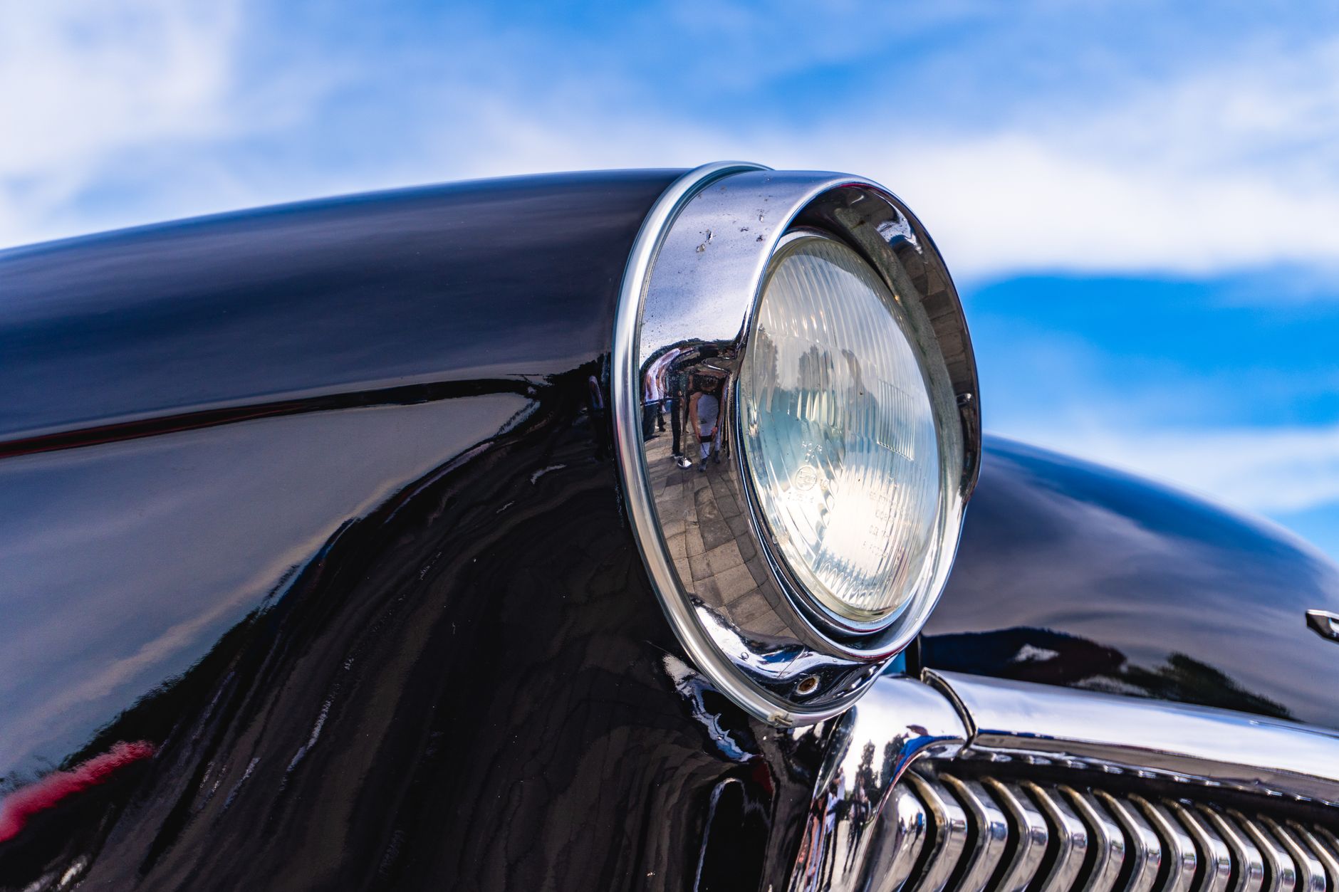 High resolution image of a vintage car's headlight reflecting the sky in Baku, Azerbaijan.