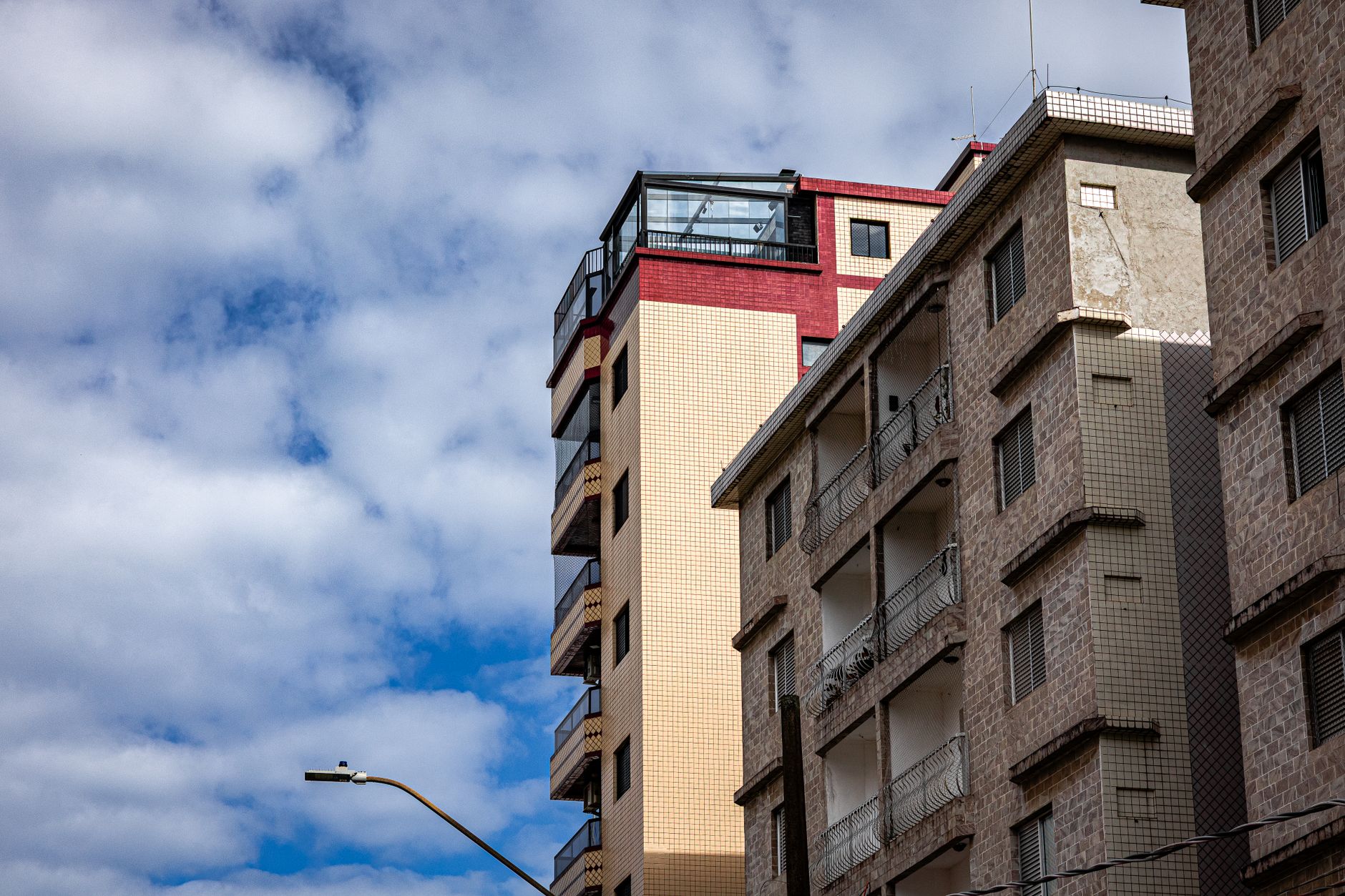 Cityscape showing modern residential buildings against a cloudy sky.