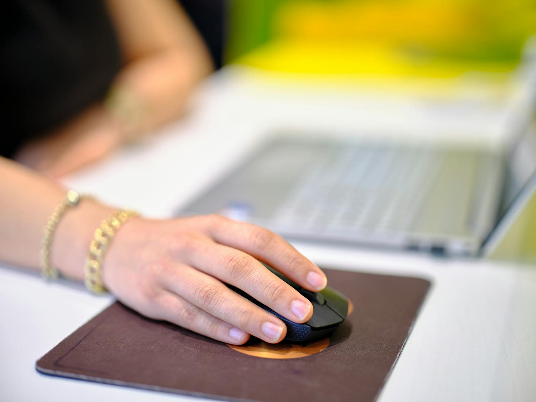 A person using a wireless mouse at a desk, perfect for business or technology themes.