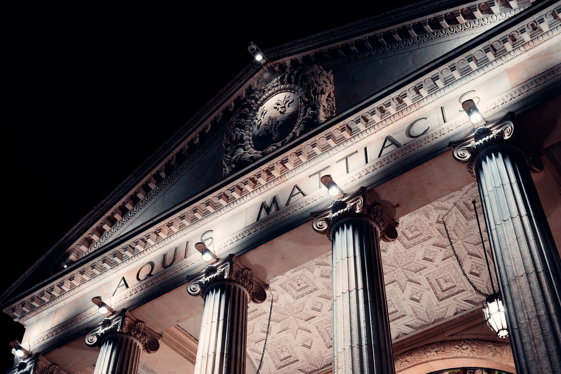 Dramatic night view of historic columns at Wiesbaden's landmark building.