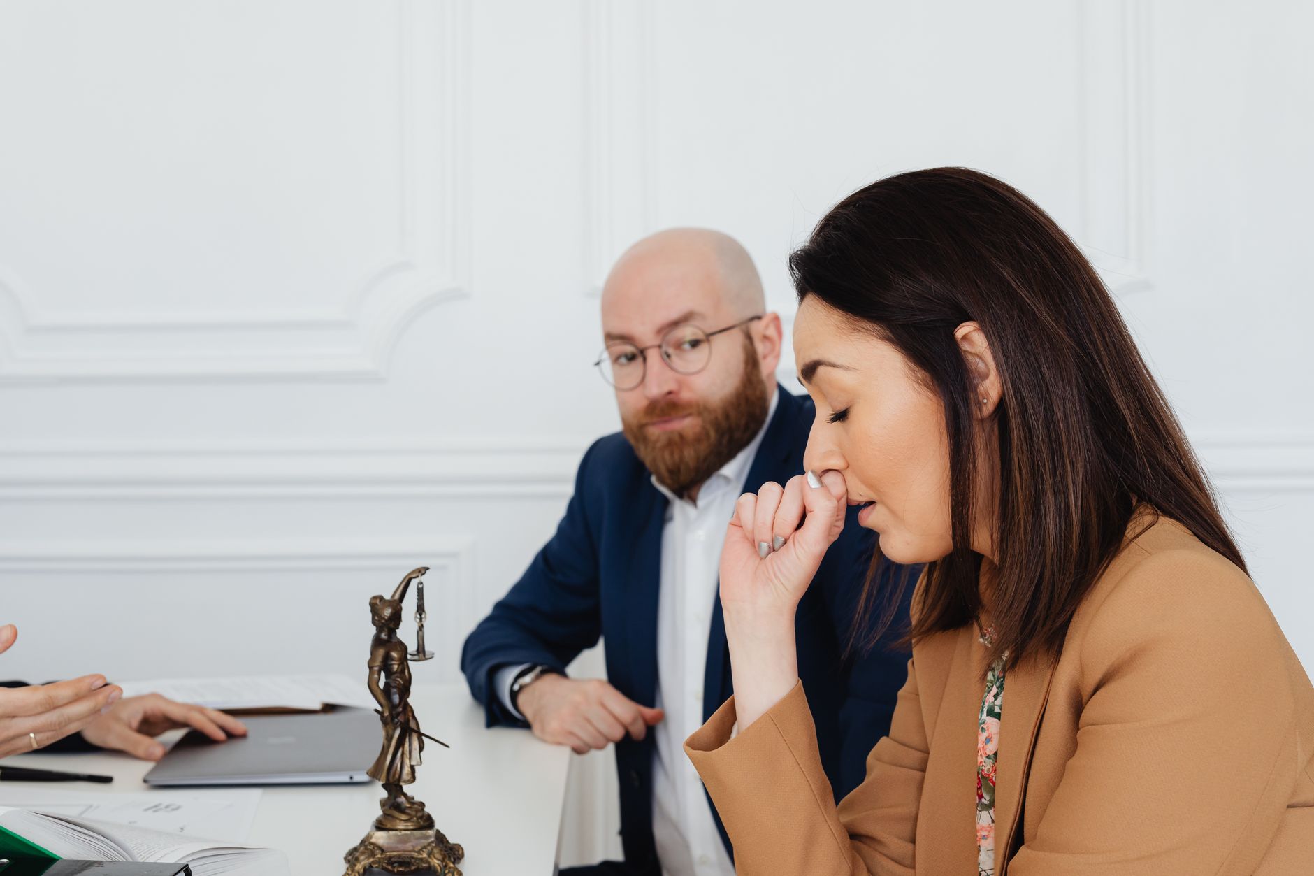 Lawyers in a serious discussion at a law office, showcasing concern and contemplation.