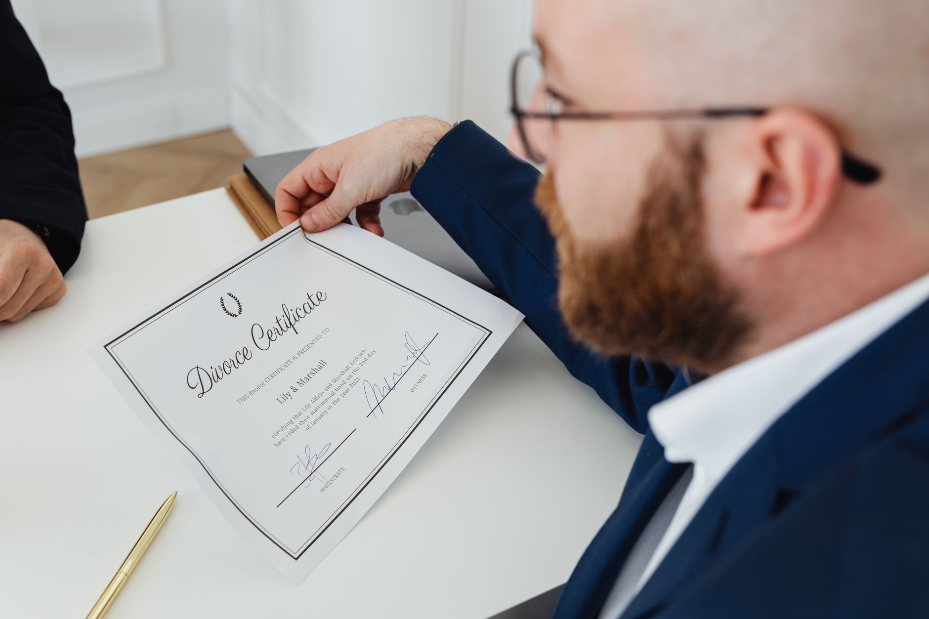 A man holding a divorce certificate in a formal office environment.