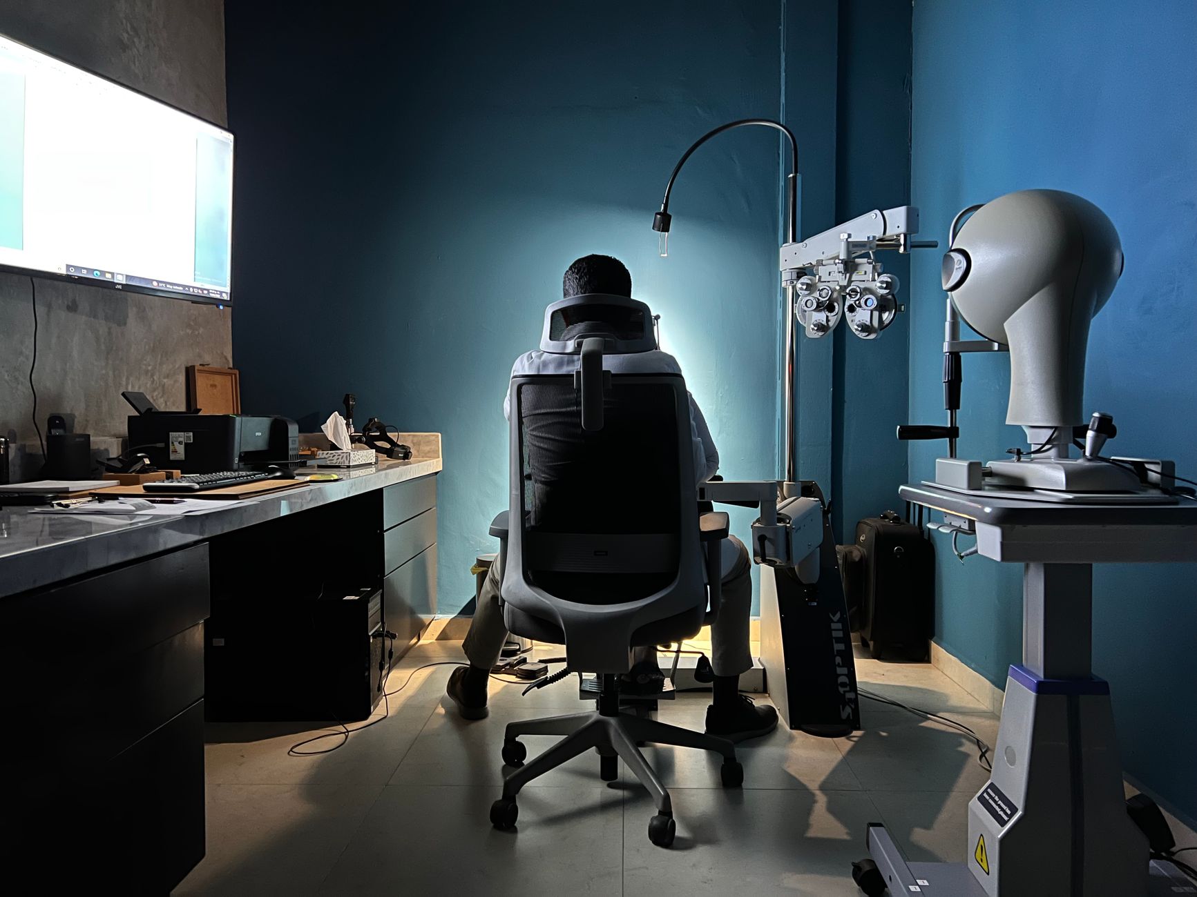 Back view of an eye care professional in a modern examination room in Los Mochis, Mexico.