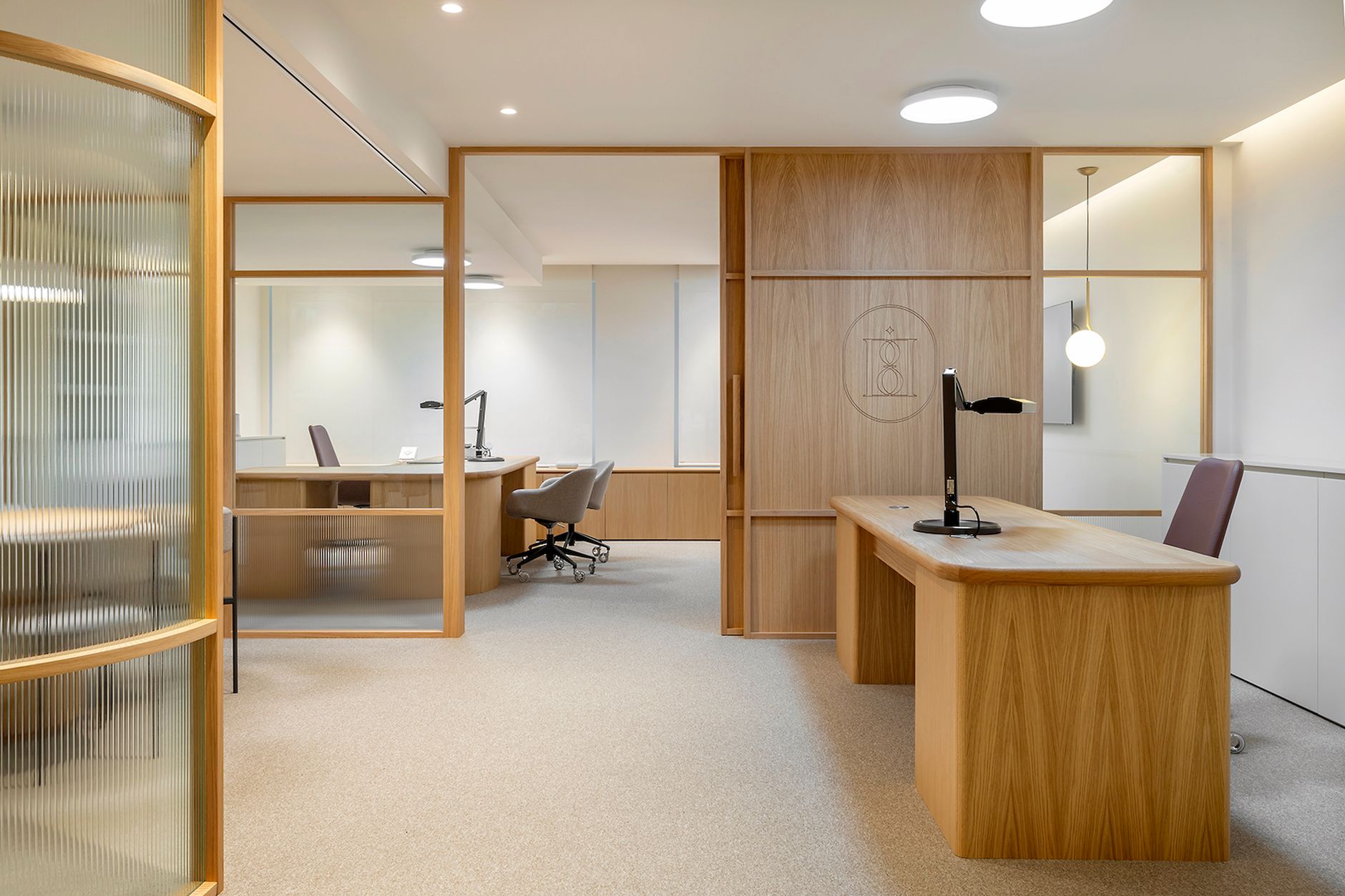 Sleek modern office with wooden furniture in Barcelona, featuring bright lighting and open space.