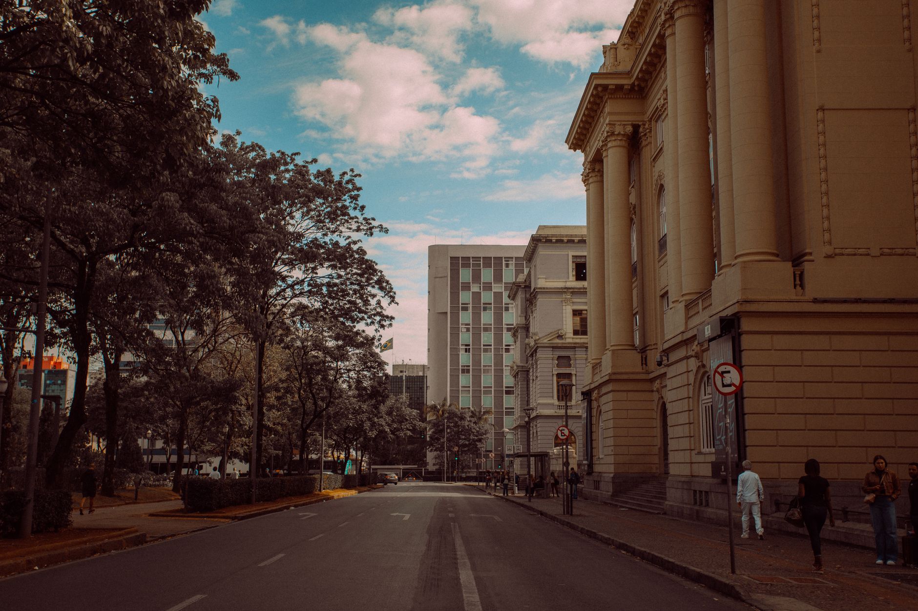 Street scene with historic architecture and modern buildings under a blue sky.