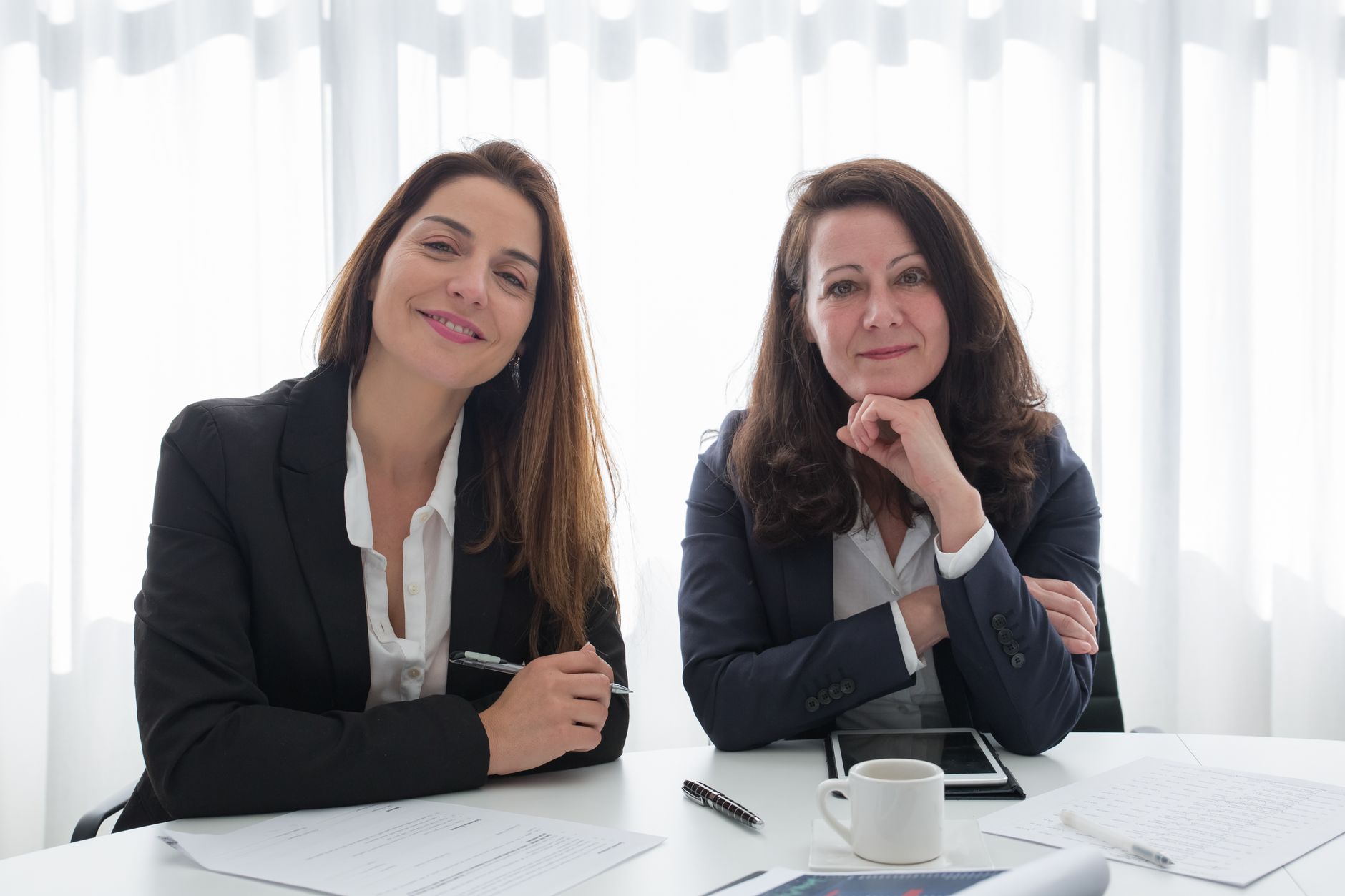 Smiling professionals in business attire at an office meeting in Portugal.