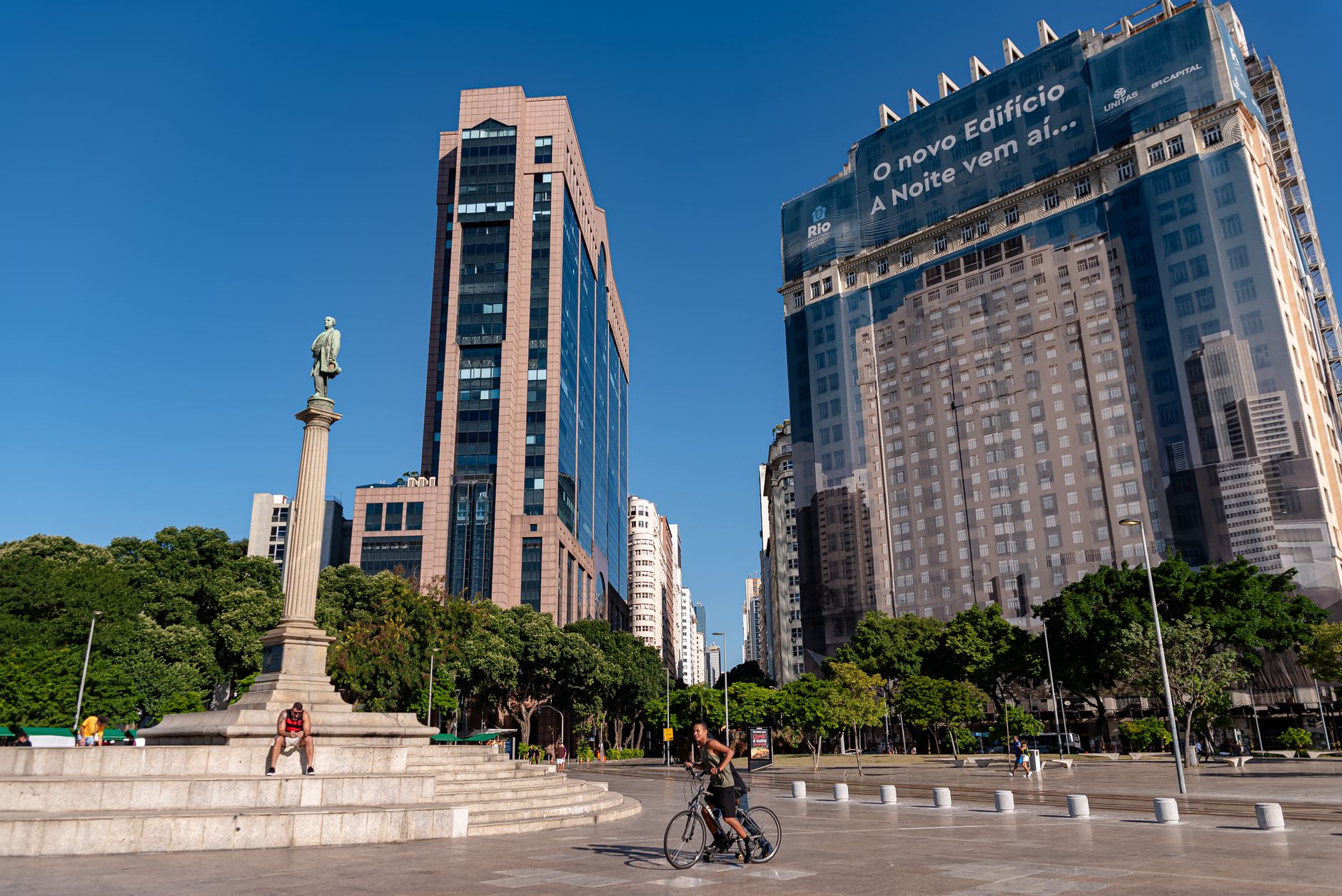 Vibrant day at Mauá Square, Rio with monument, skyscrapers, and a cyclist.