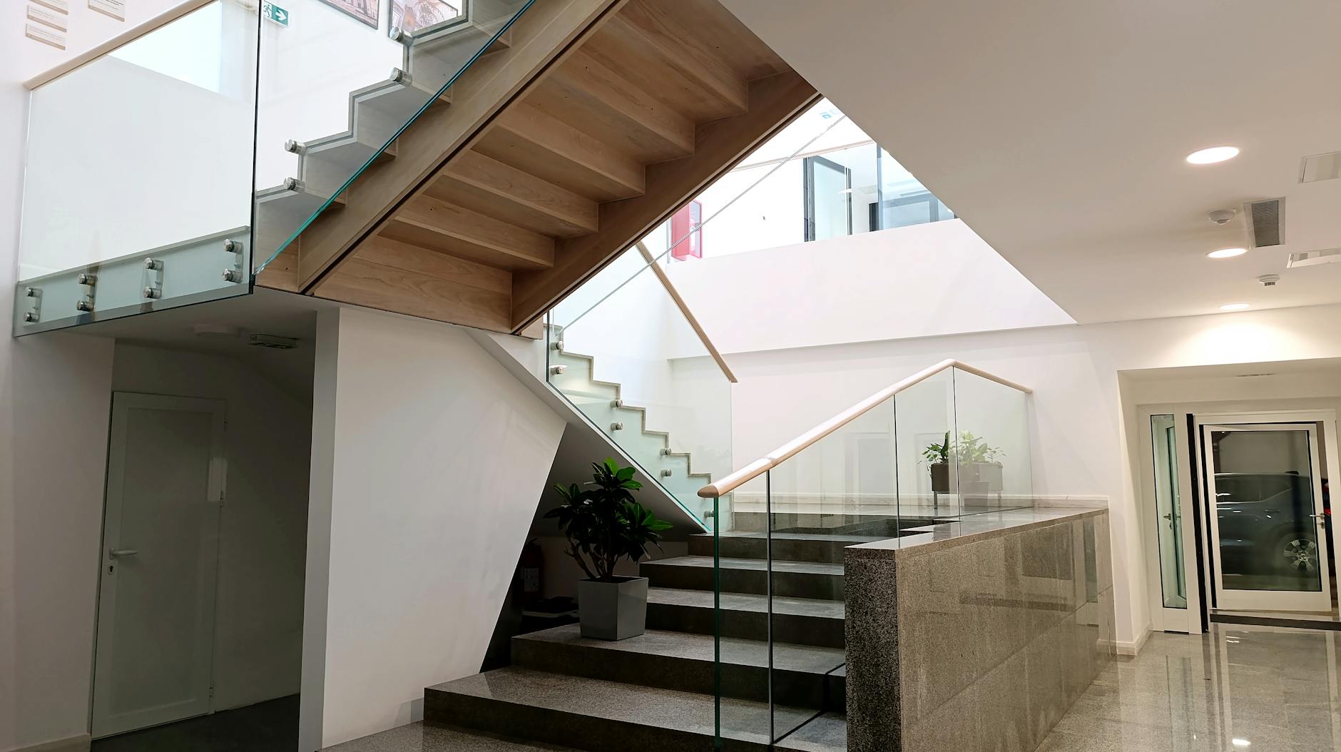 Contemporary indoor staircase with glass railings and sleek design, showcasing modern architecture.