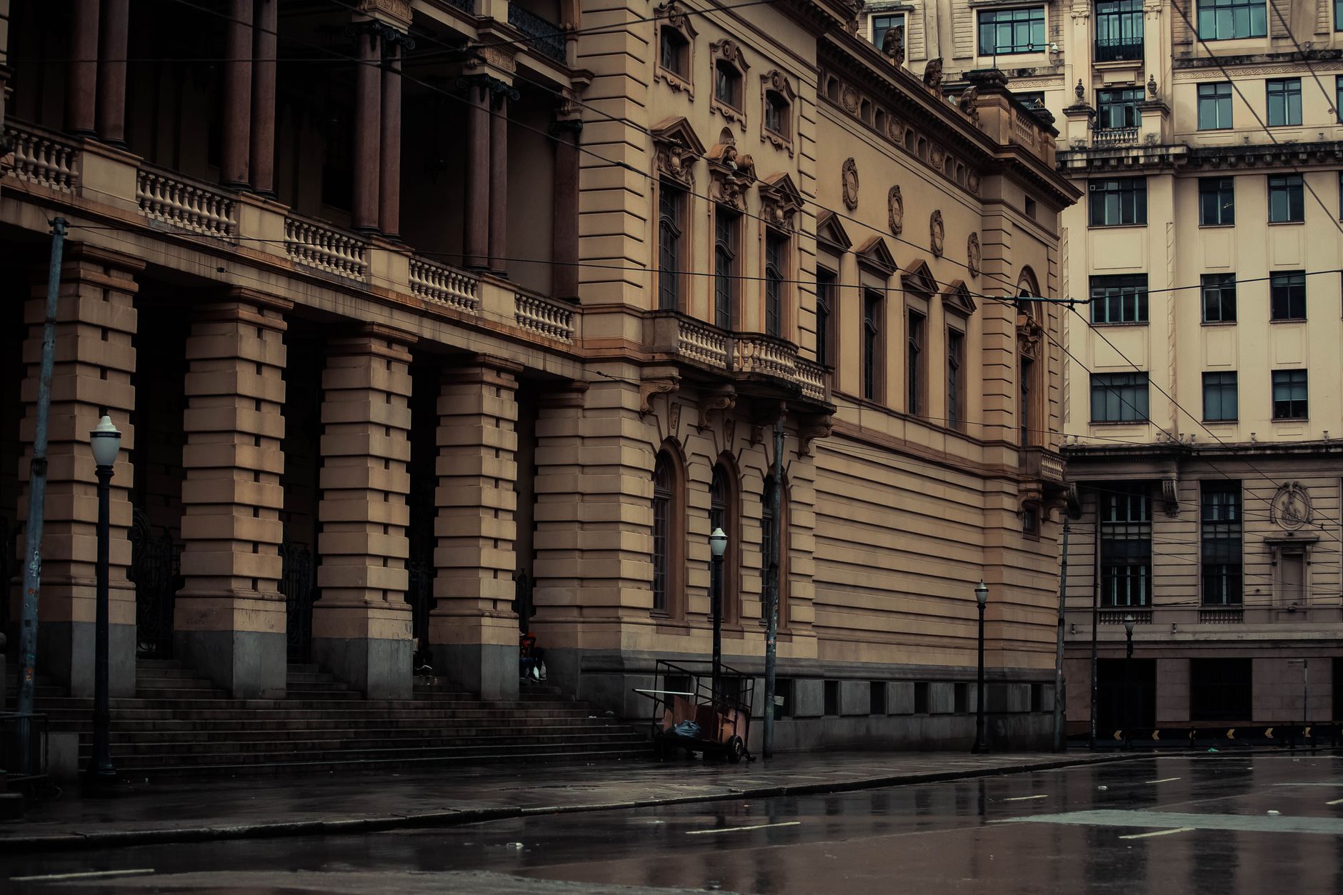 Moody view of Municipal Theatre of Sao Paulo with wet streets and classic architecture.