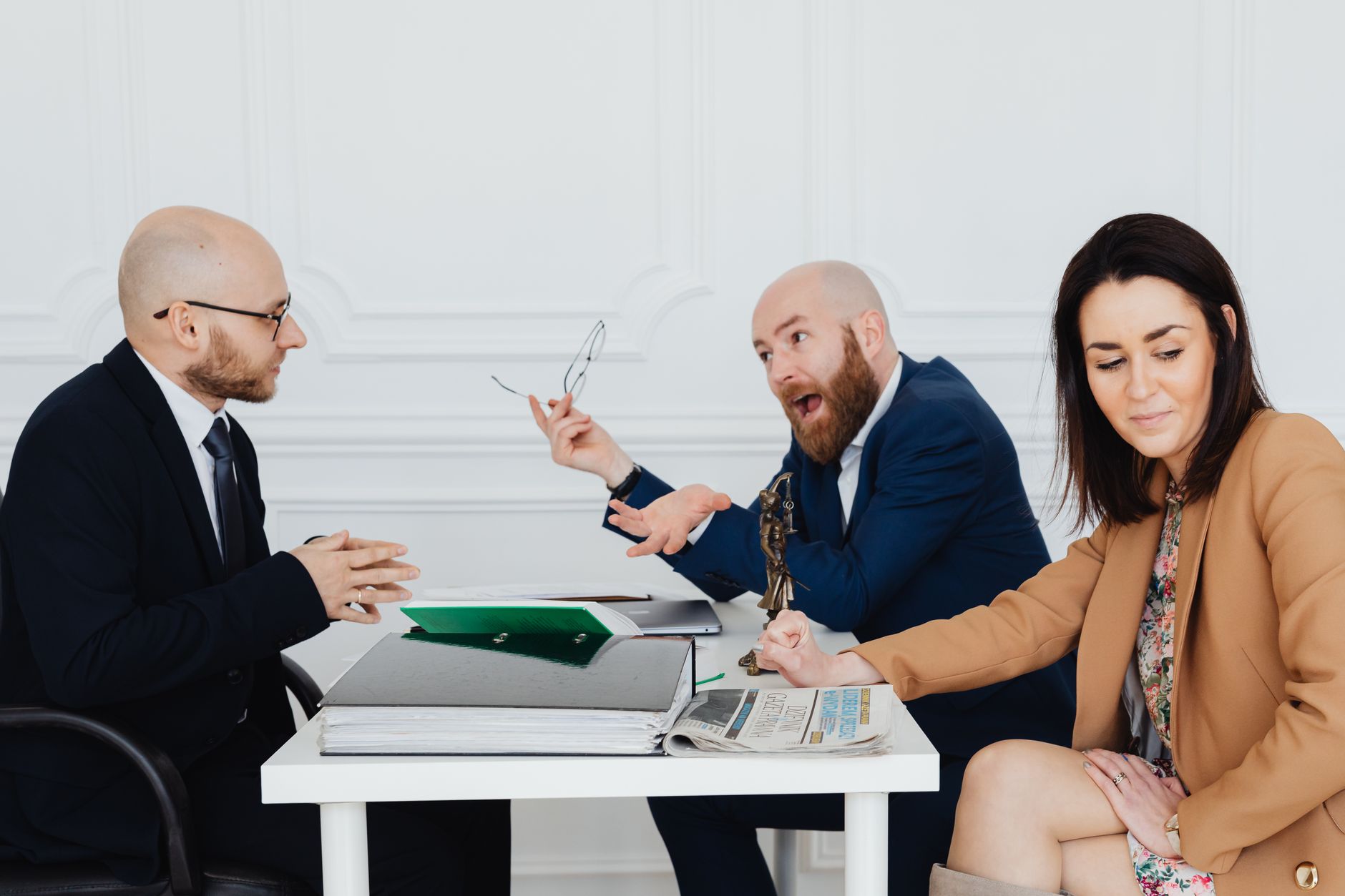 A heated discussion between two men and a woman in a corporate office setting.