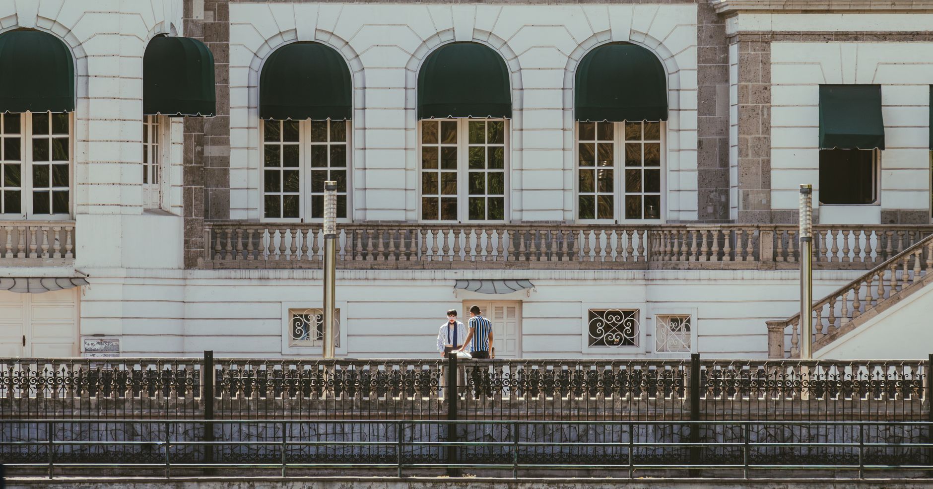 A historic building facade with two adults conversing in Mexico City.