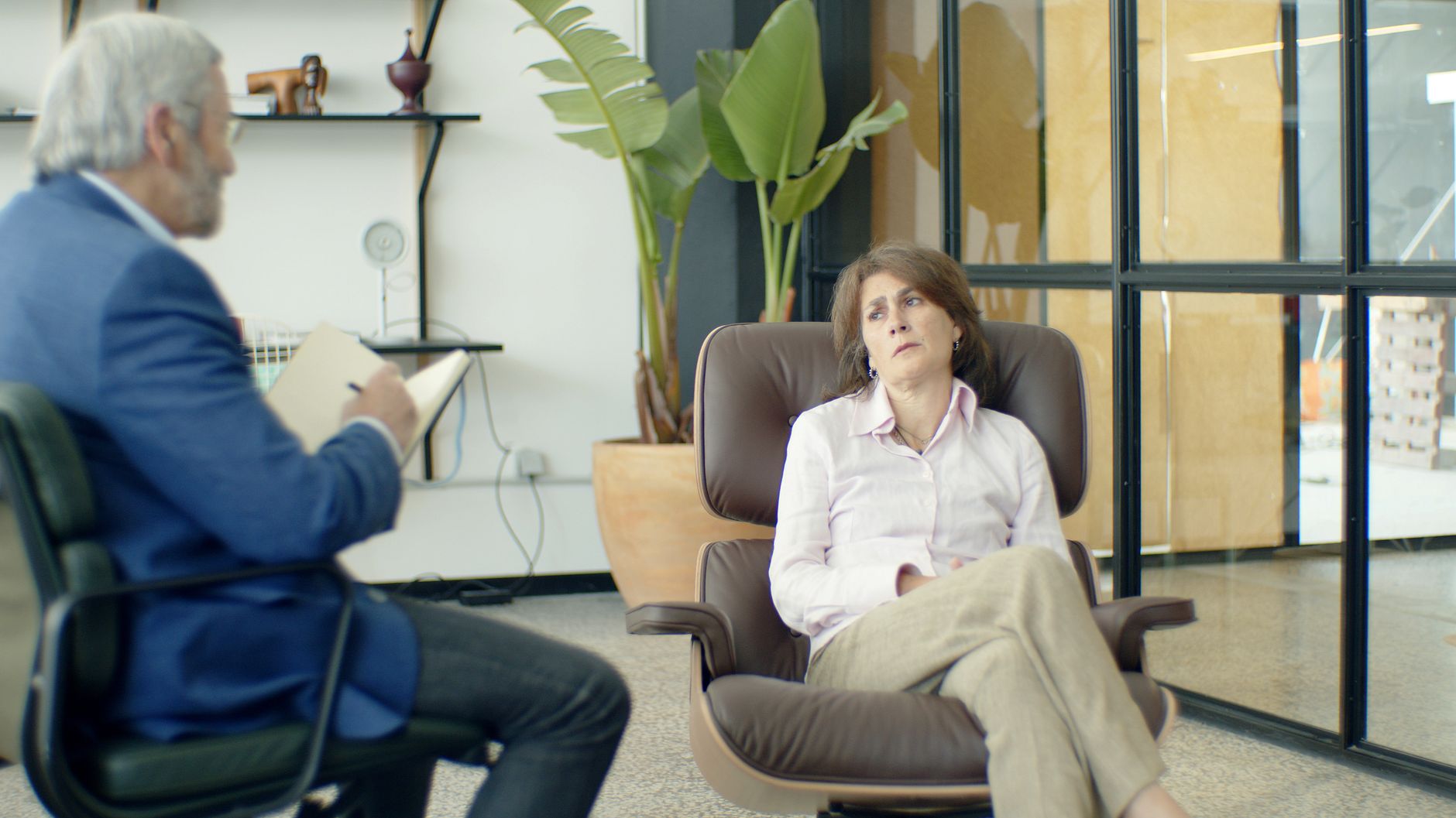 Therapist and client during a psychotherapy session in a modern office.