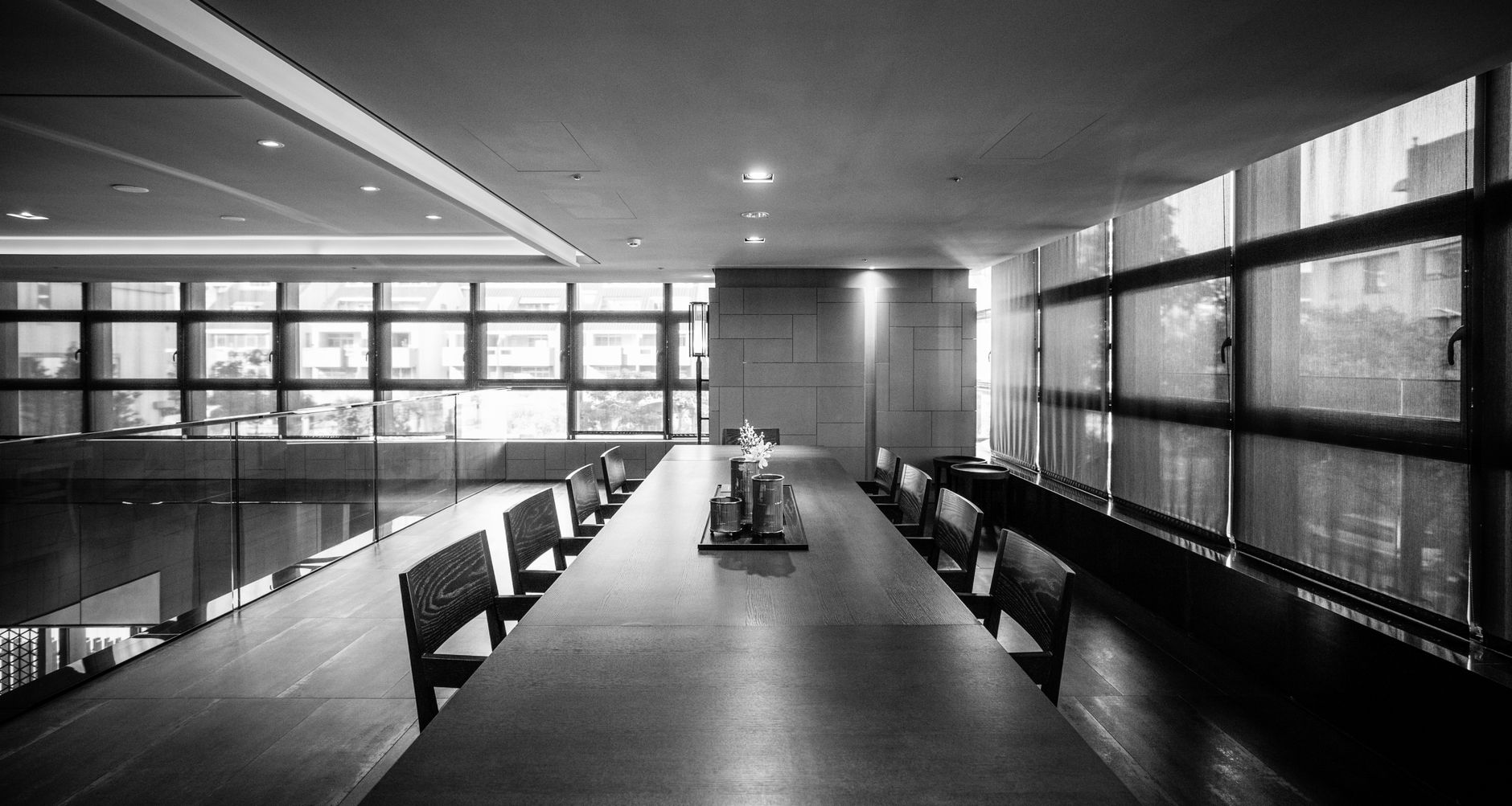 Elegant black and white photo of a modern conference room with wooden furniture.