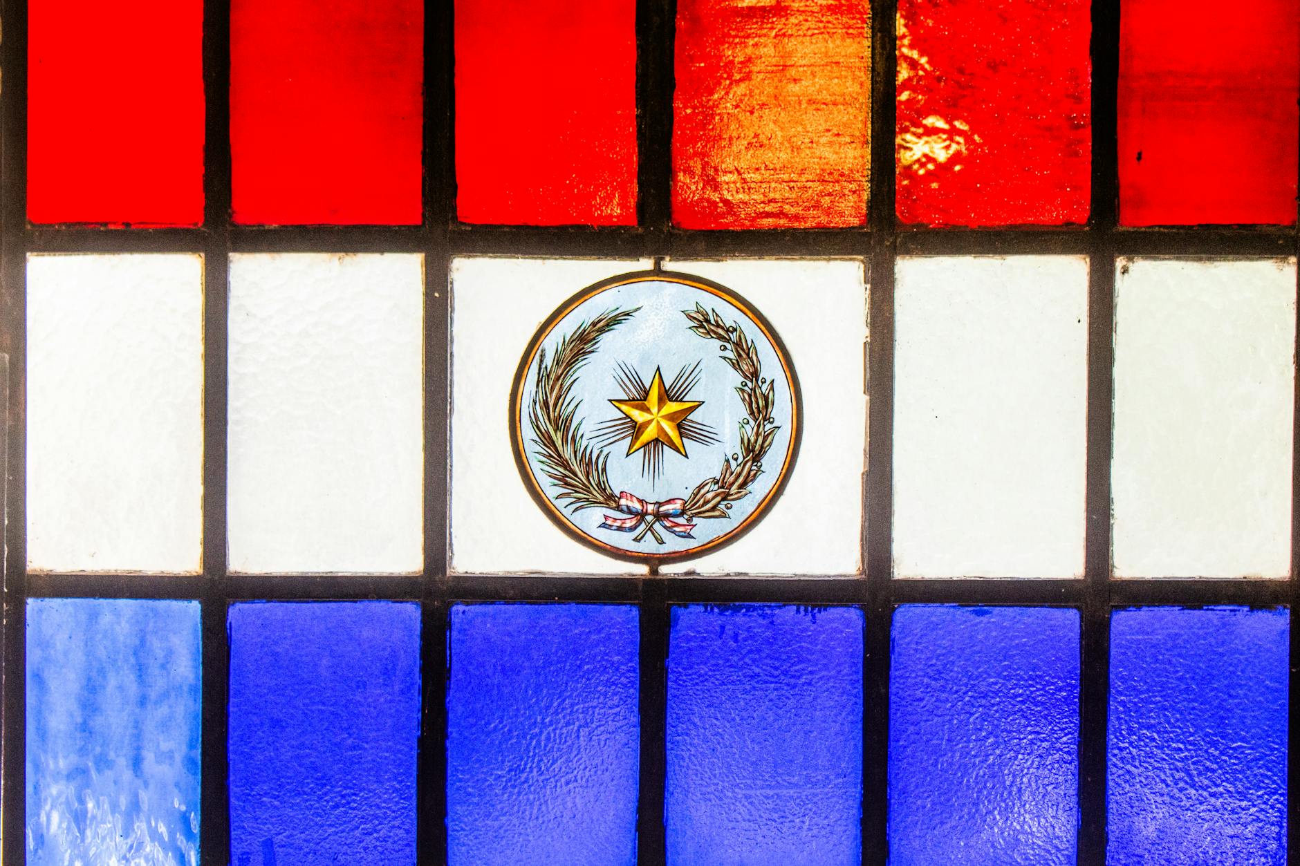 Stained glass in red, white, and blue featuring Paraguay's emblem. Symbol of patriotism in Asunción.