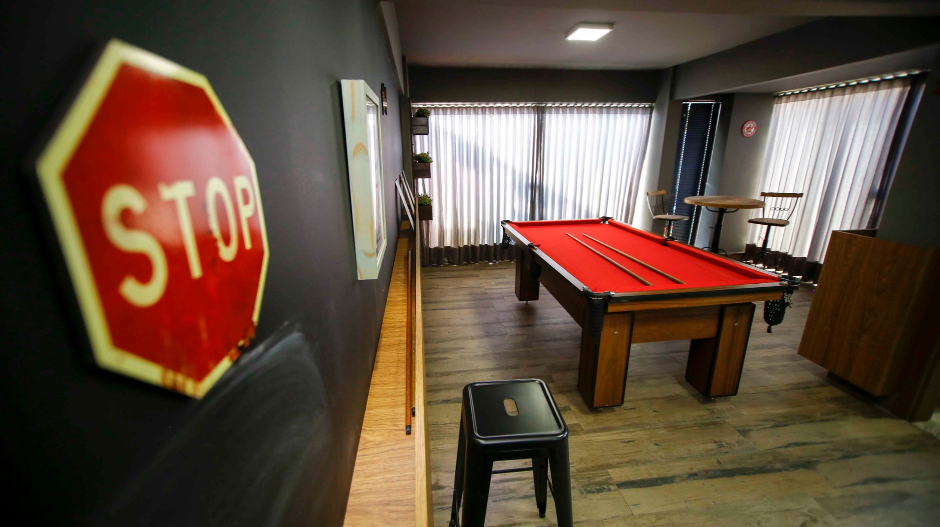 Indoor space featuring a red billiard table and modern decor elements.