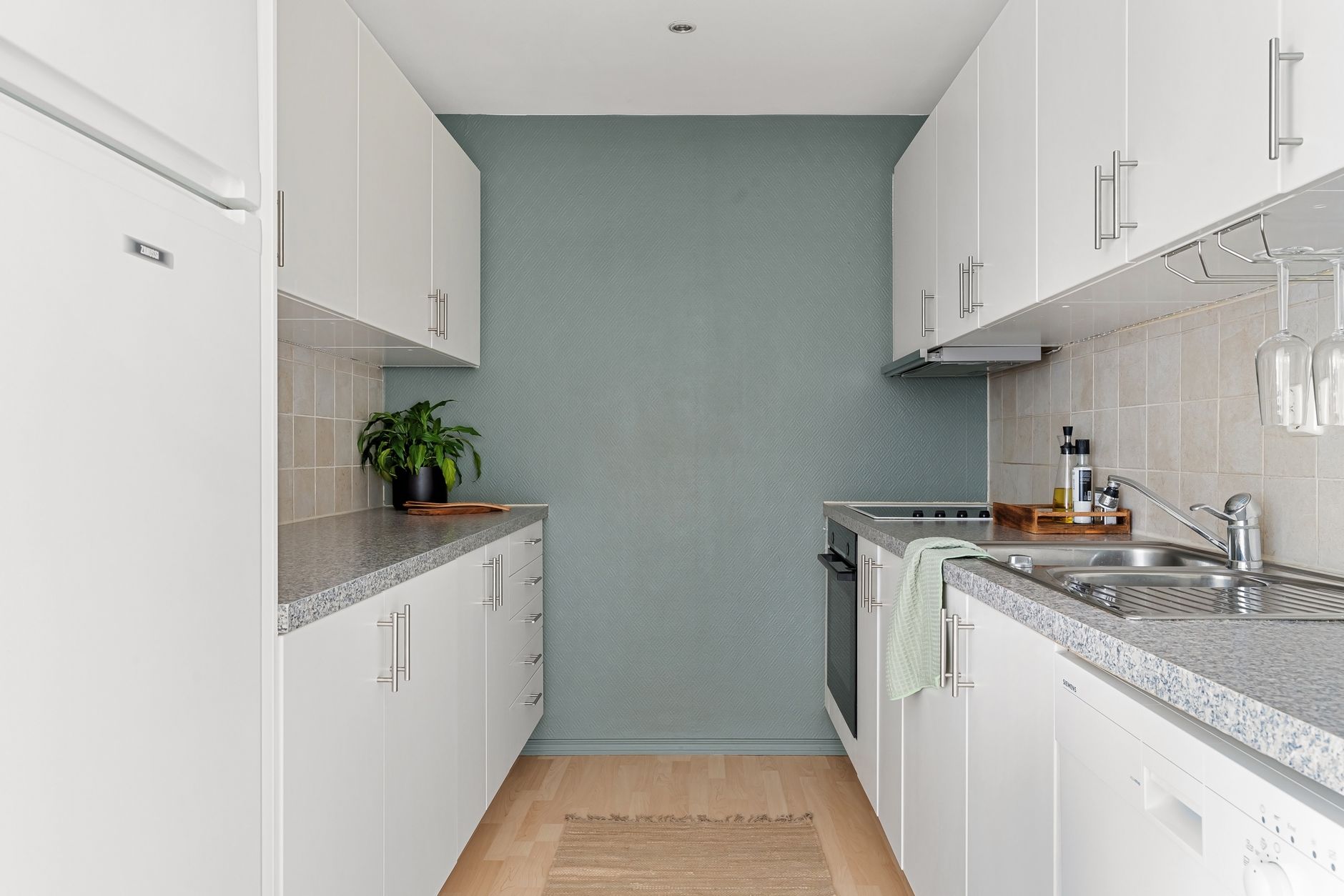 A sleek, modern kitchen with white cabinets, granite countertops, and stainless steel appliances.