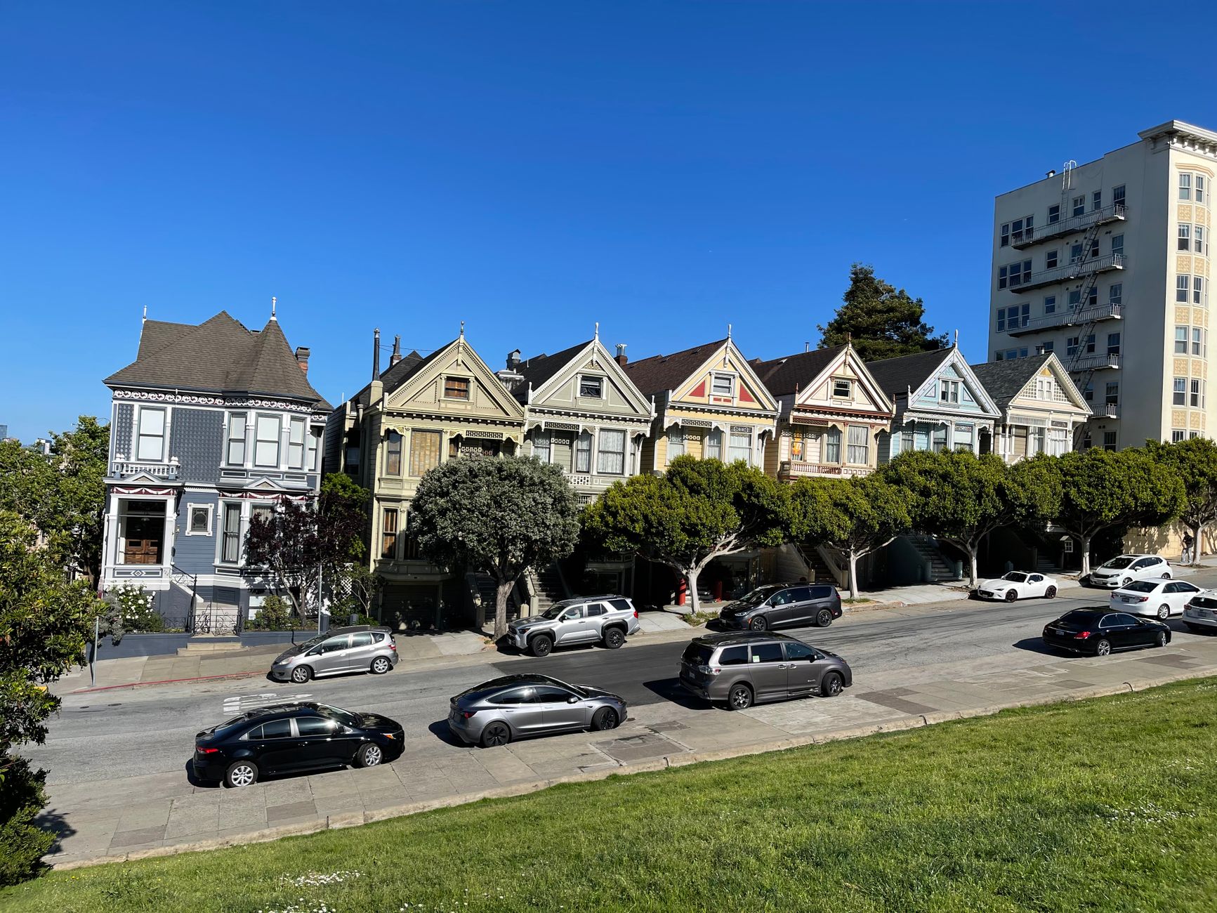 View of the famous Painted Ladies houses in San Francisco on a sunny day with a clear blue sky.