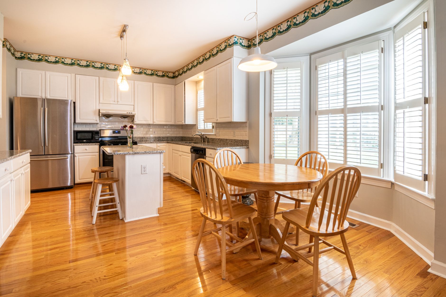 A modern kitchen featuring wooden furniture and bright lighting, perfect for family dining and cooking.