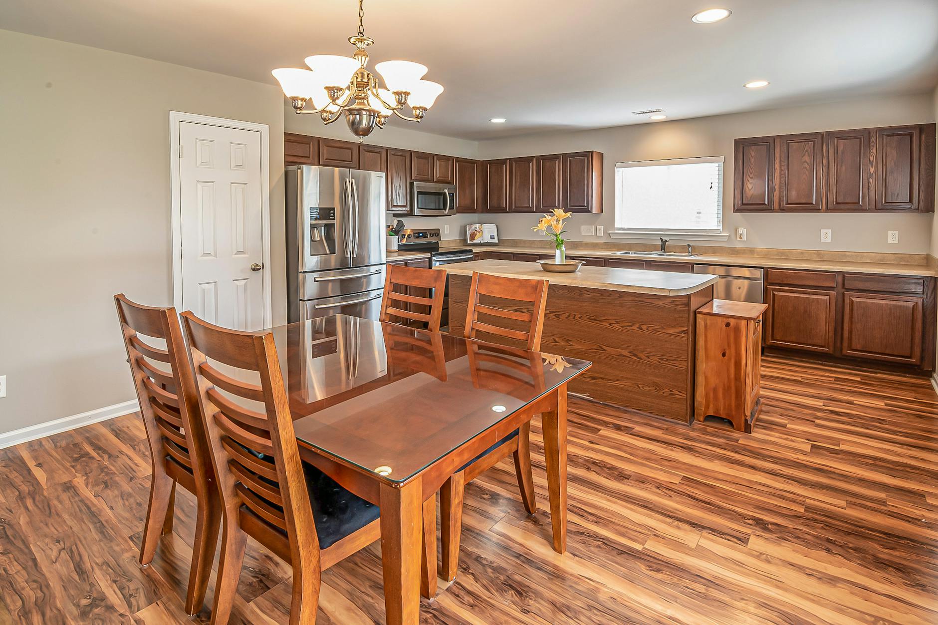 A modern kitchen and dining area featuring wooden floors and cabinetry, perfect for home design inspiration.