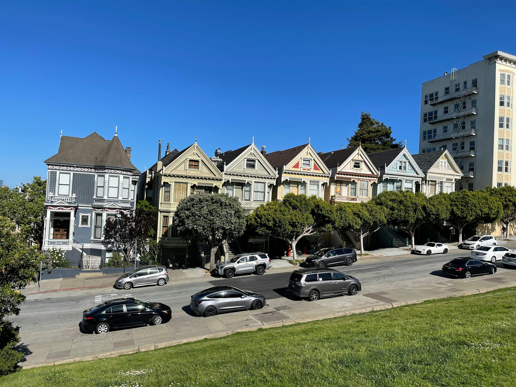 View of the famous Painted Ladies houses in San Francisco on a sunny day with a clear blue sky.