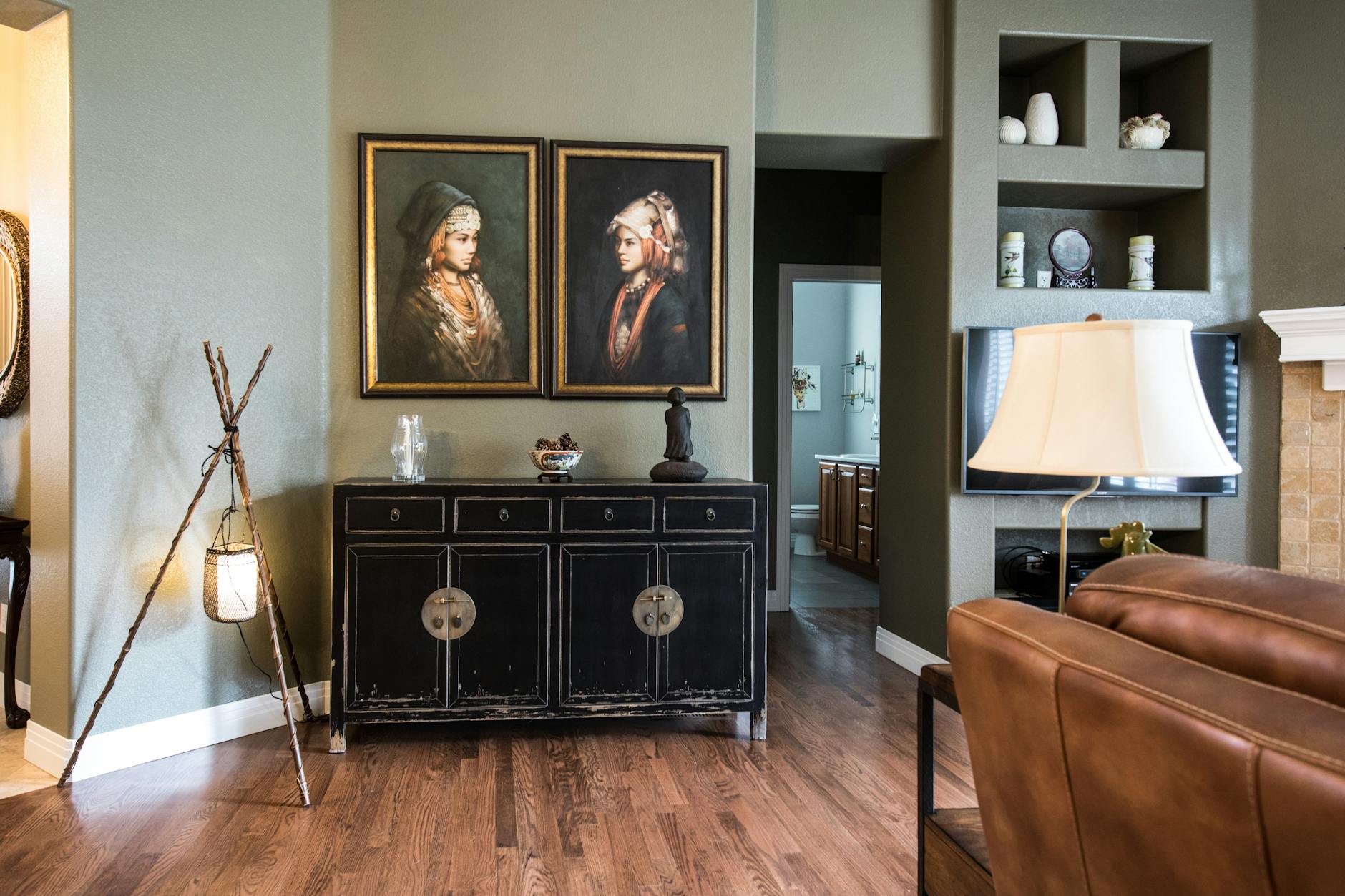 Stylish living room with classic art, vintage cabinet, and chic decor.