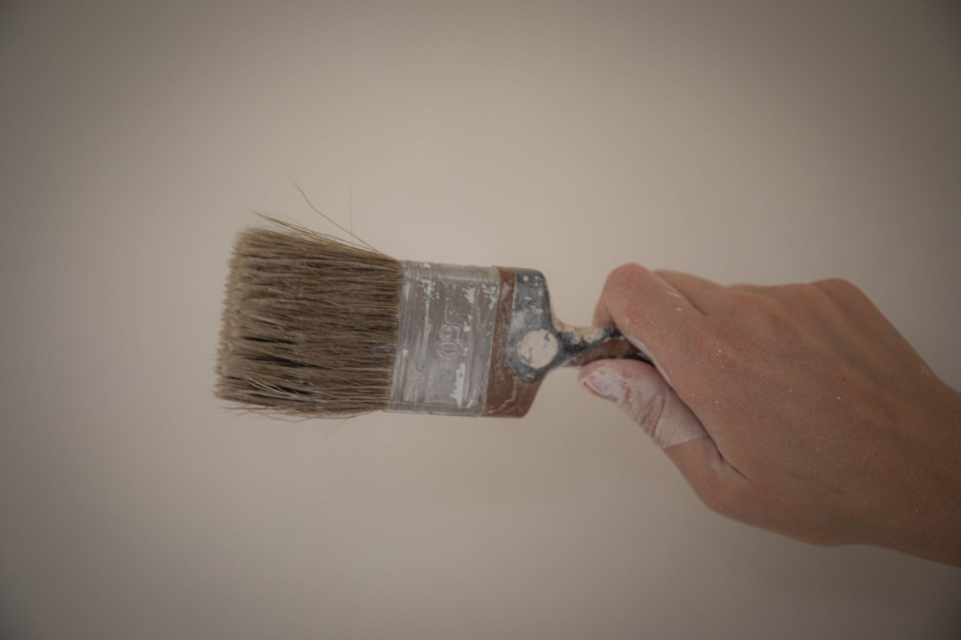 Hand gripping a paintbrush, ready for painting. Ideal for artistic themes.
