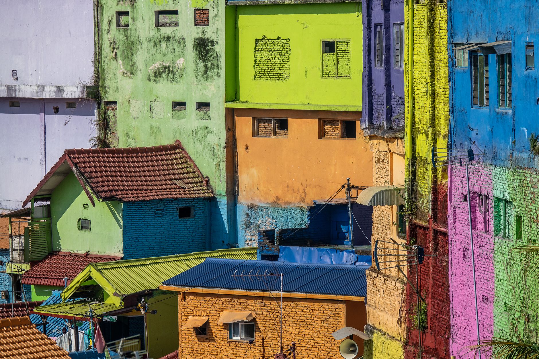 Brightly colored urban houses with vibrant painted facades create a lively cityscape.