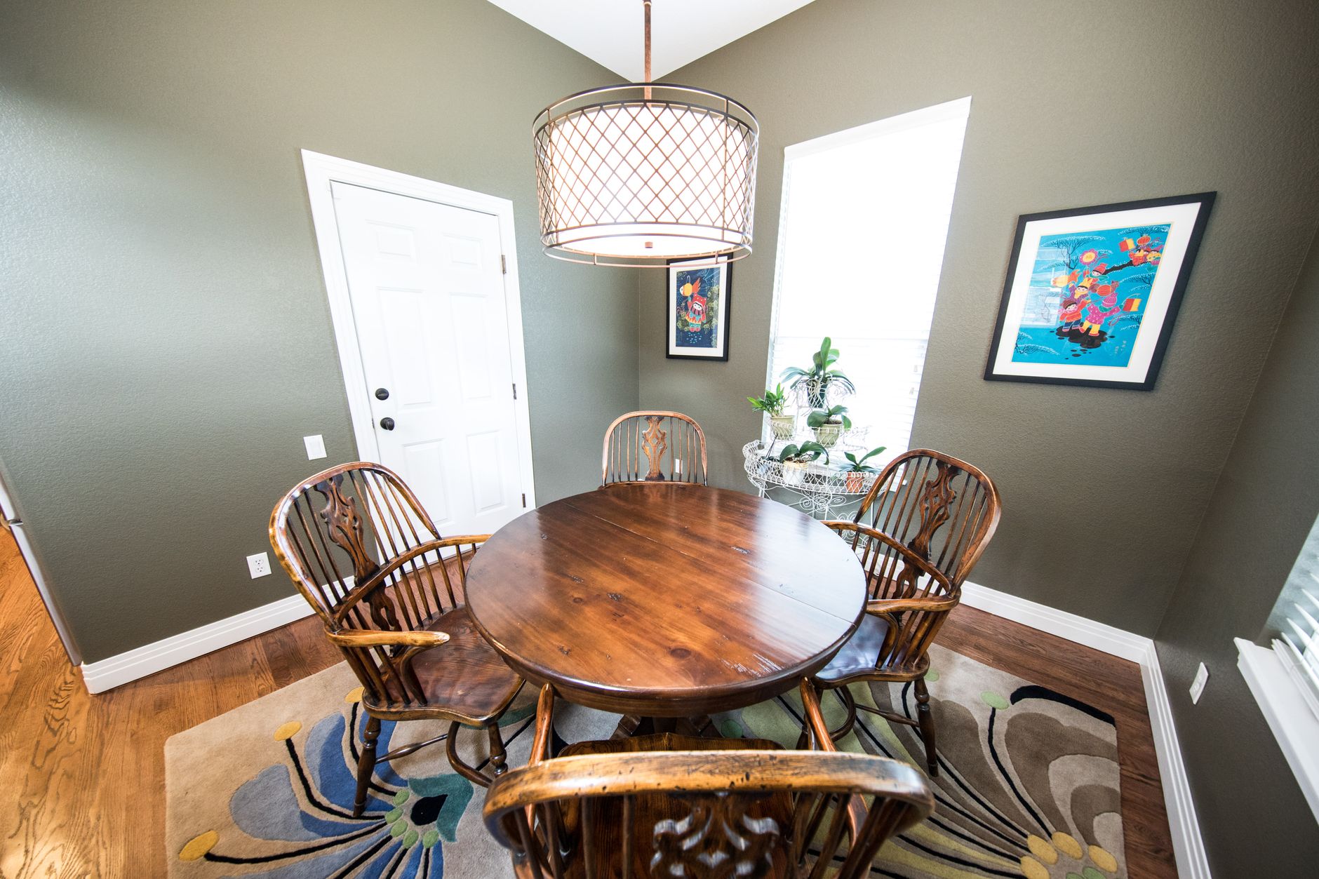 A stylish dining room featuring a round wooden table, chairs, and modern decor.