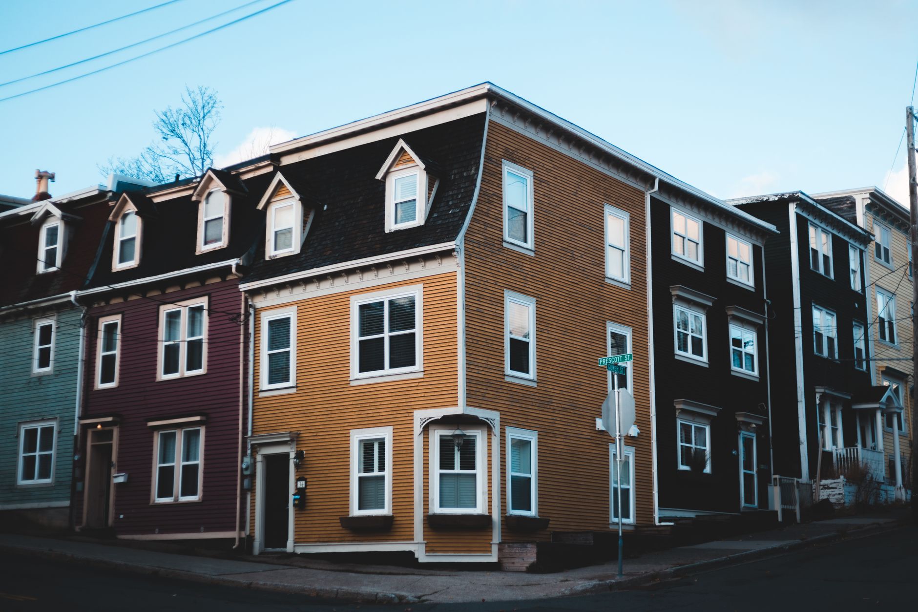 Vibrant row houses line an urban street, showcasing unique architectural design and colorful facades.