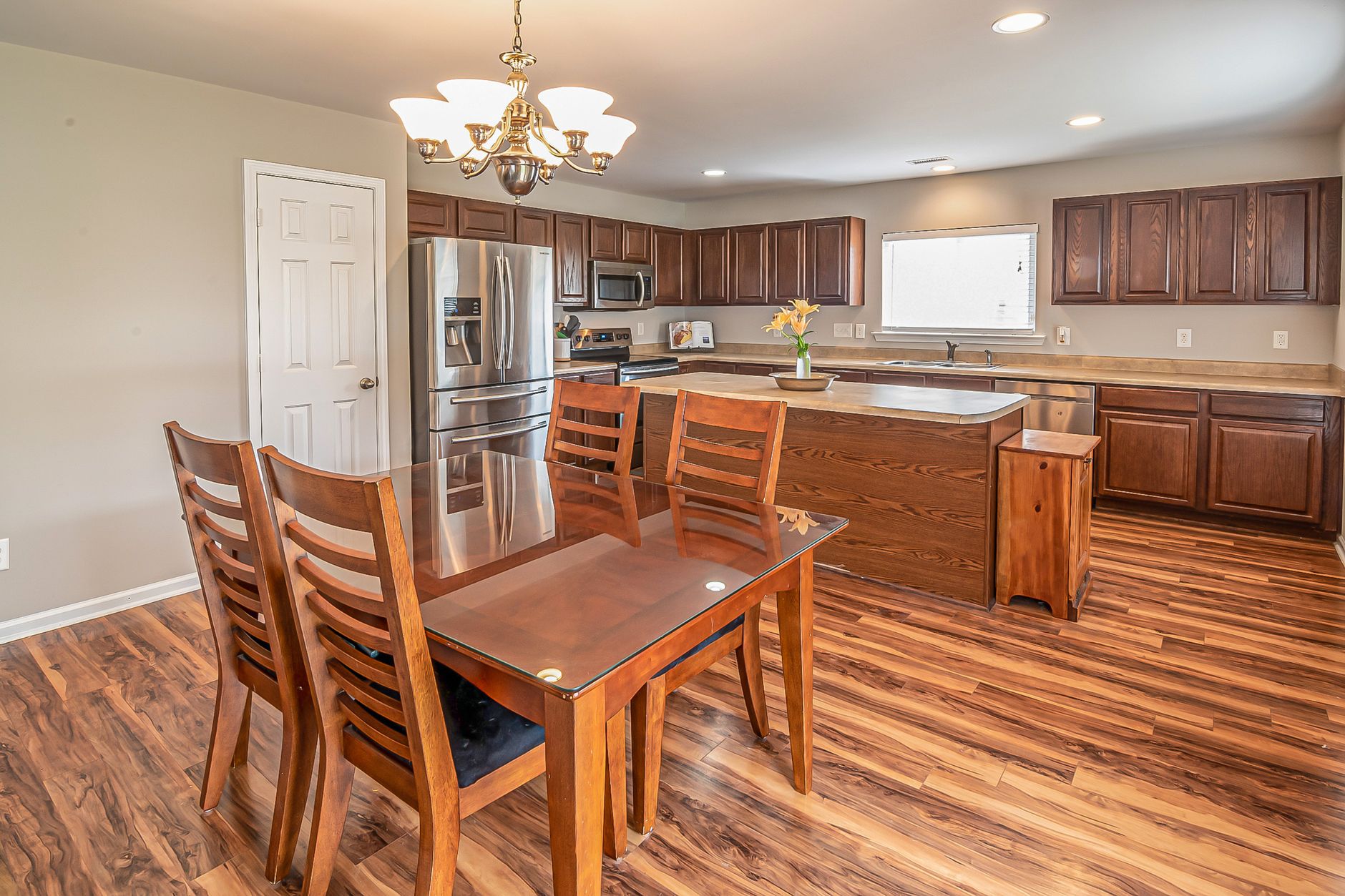 A modern kitchen and dining area featuring wooden floors and cabinetry, perfect for home design inspiration.