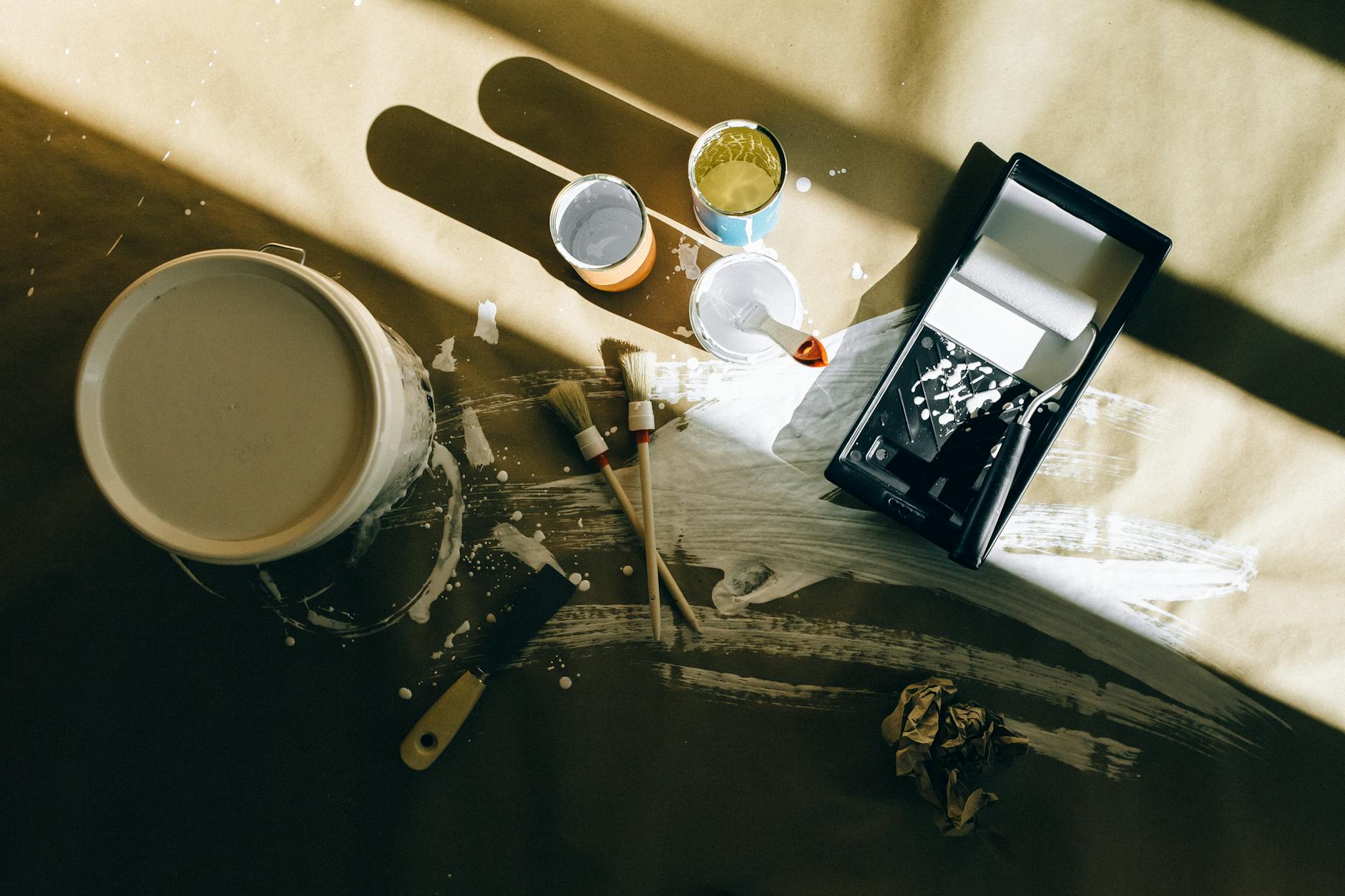Creative top view of paint tools on canvas with shadows and splatters, perfect for artistic themes.