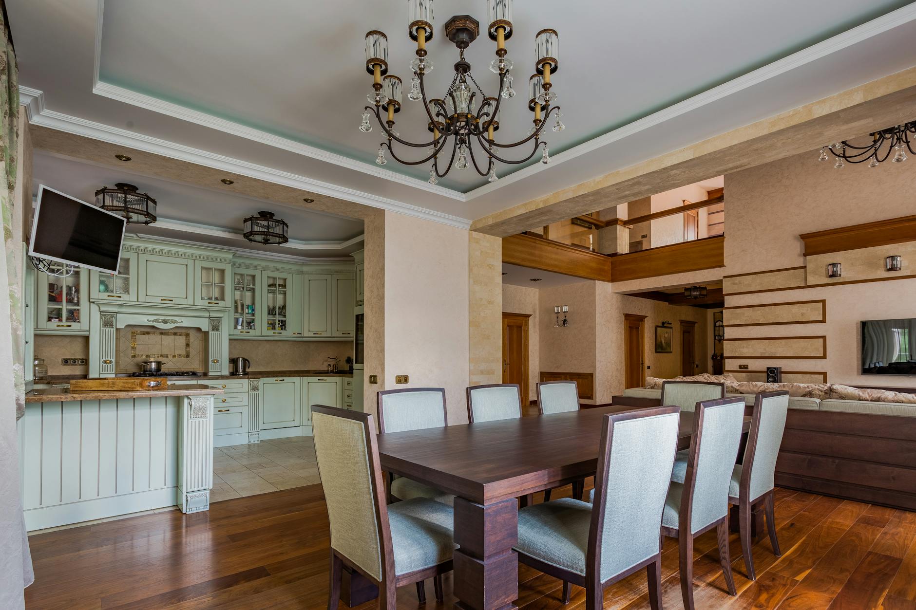 Spacious dining area with a classic chandelier and modern kitchen design.