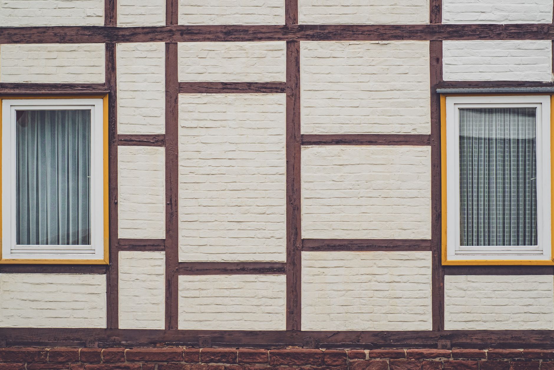 Detailed view of a half-timbered wall with two windows, highlighting traditional architecture.