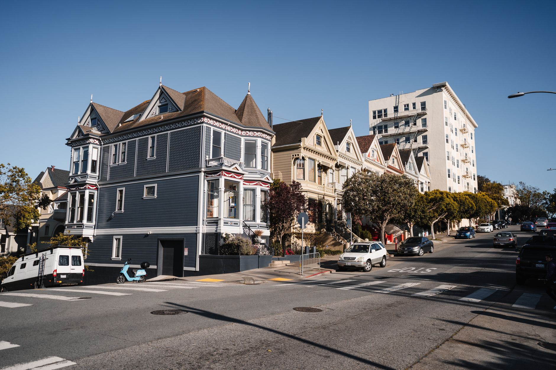 Quaint Victorian houses along a sunlit street in San Francisco, California.