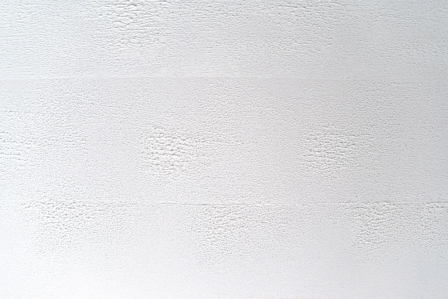 Close-up of a white textured wall, perfect for backgrounds or design elements.