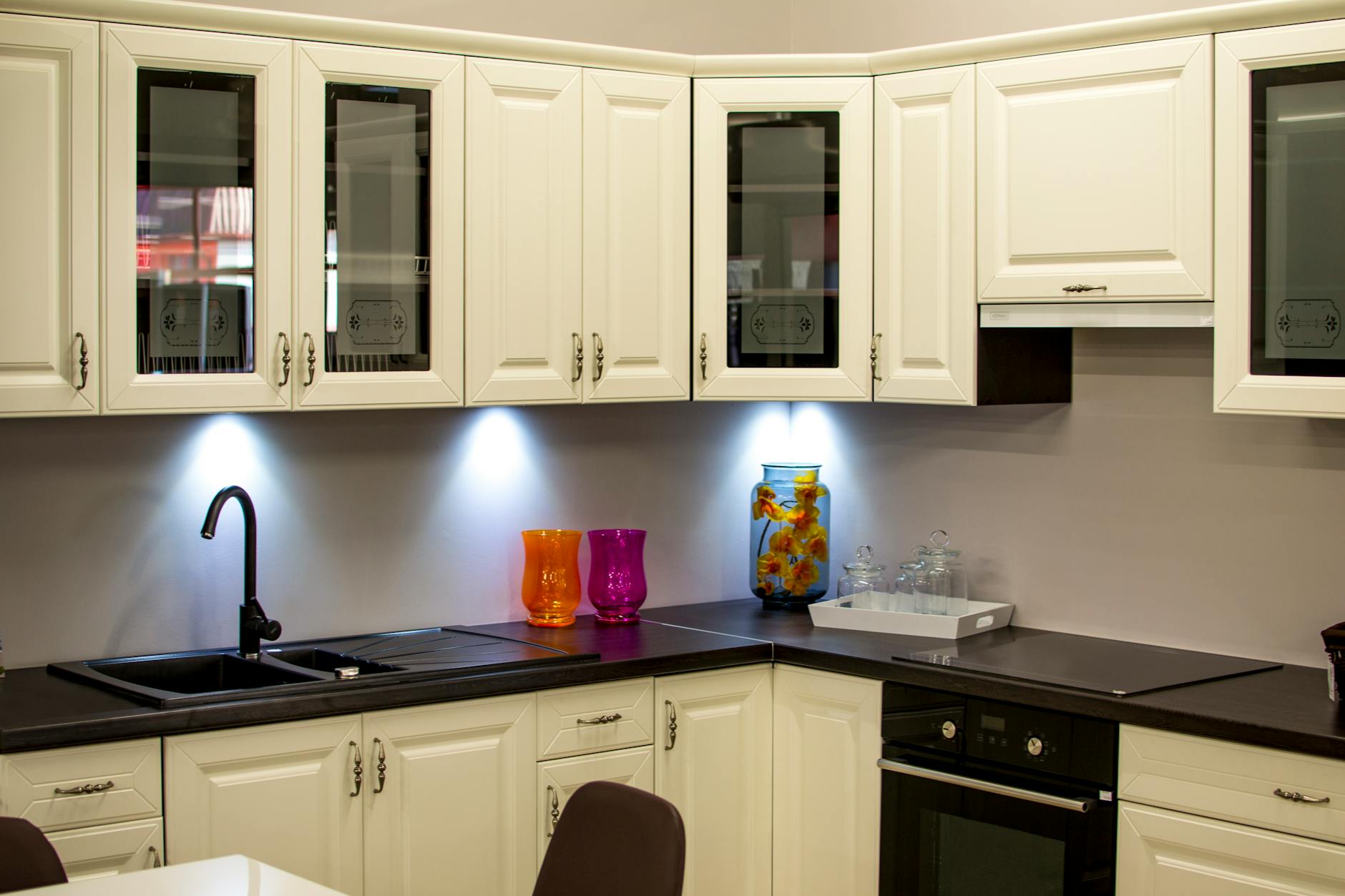 A stylish modern kitchen with white cabinets and colorful decor pieces.