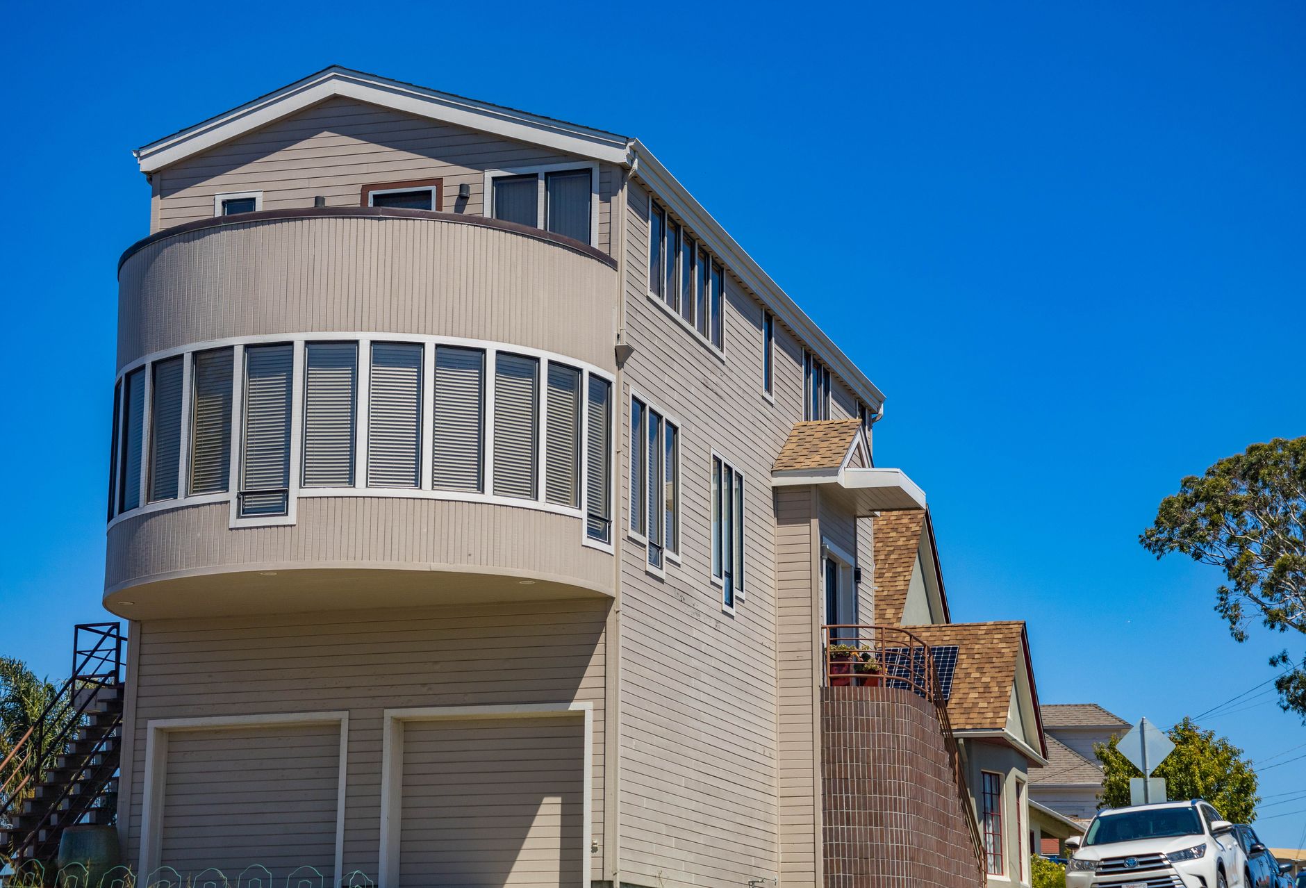A modern suburban house with unique architectural design and clear blue sky backdrop.