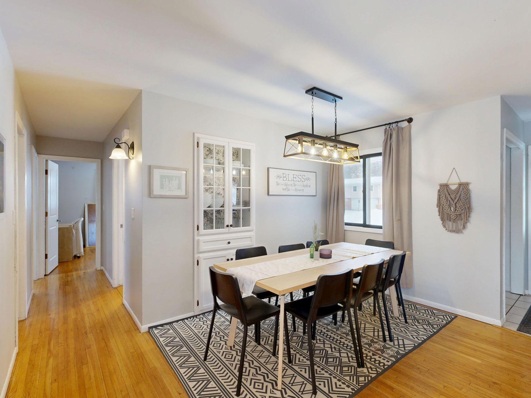 Cozy modern dining room with a stylish chandelier and minimalist decor. Bright and inviting.