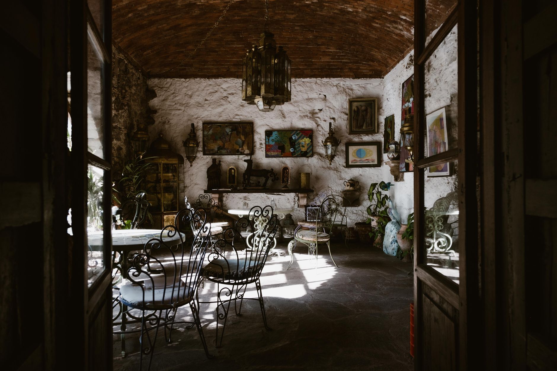 Explore this rustic interior highlighting vintage style with wrought iron furniture and eclectic decorations.
