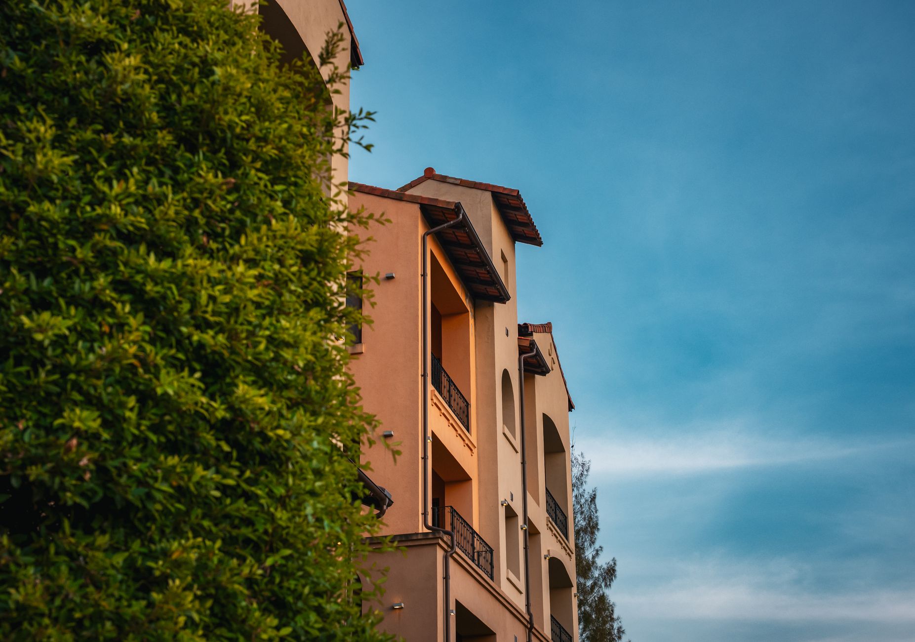 Beautiful Mediterranean-style building with lush greenery under a clear sky in Thailand.